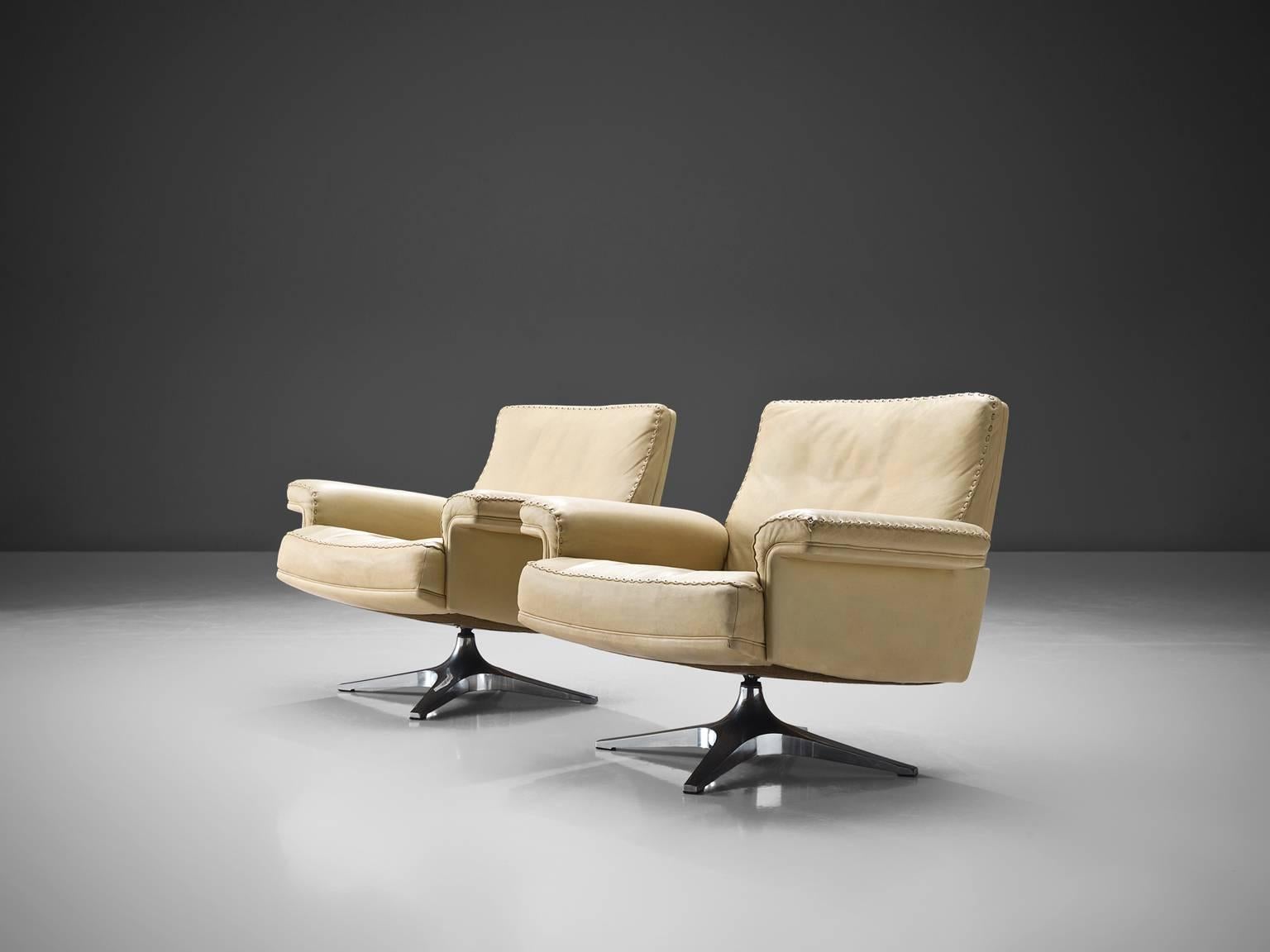 De Sede, pair of DS 31 chairs, leather, steel, Switzerland, 1970s.

This is a set of two De Sede swivel chairs in off-white leather and steel. The seats are formed as comfortable shells with two wide armrests. The chairs lean slight backwards in