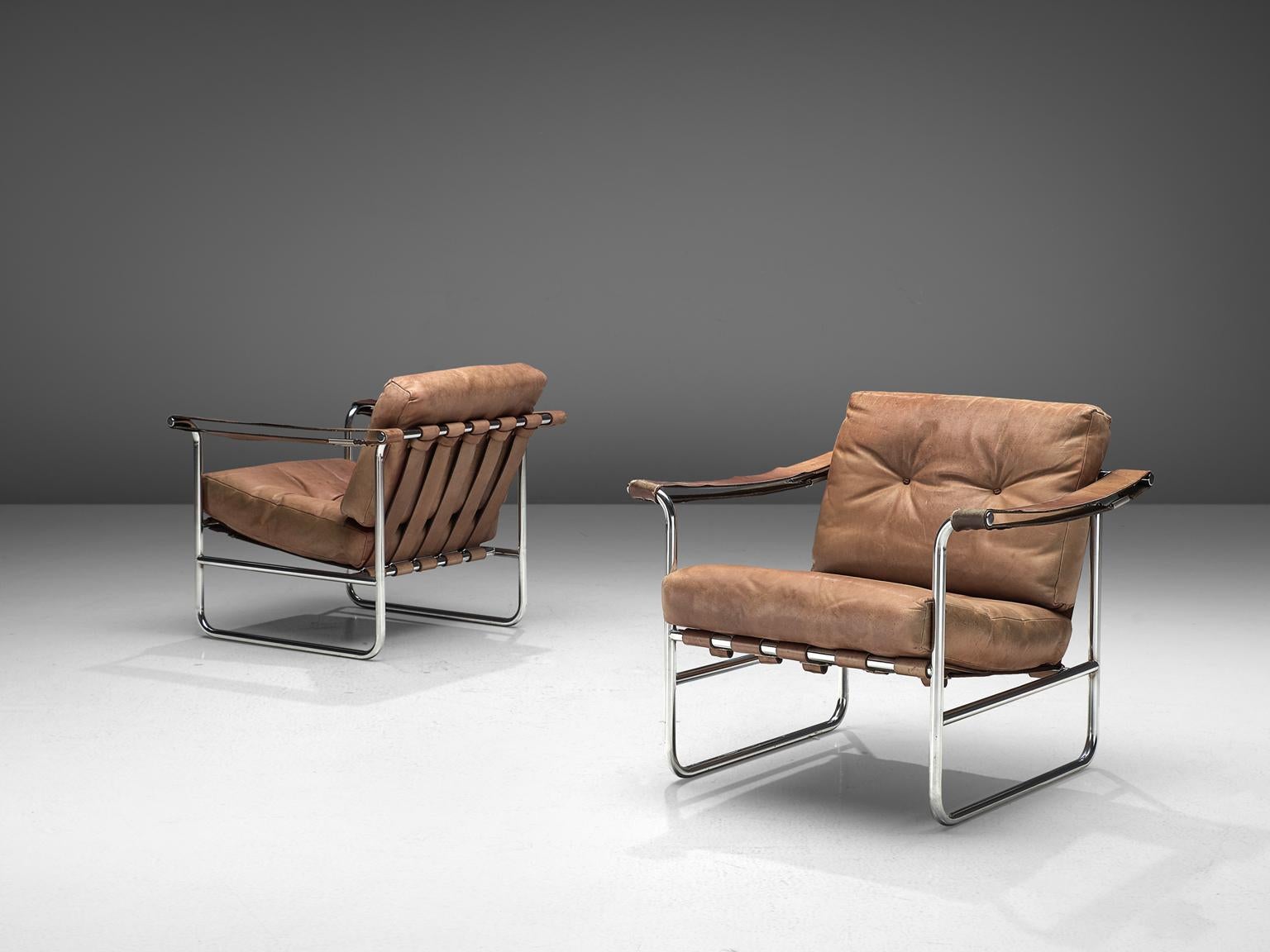 Hans Eichenberger for De Sede, set of armchairs HE 113, beige to cognac leather, tubular steel, Switzerland, 1956.

This set of Swiss armchairs features a tubular frame with a thick comfortable seat and back cushion. The back of the chairs is