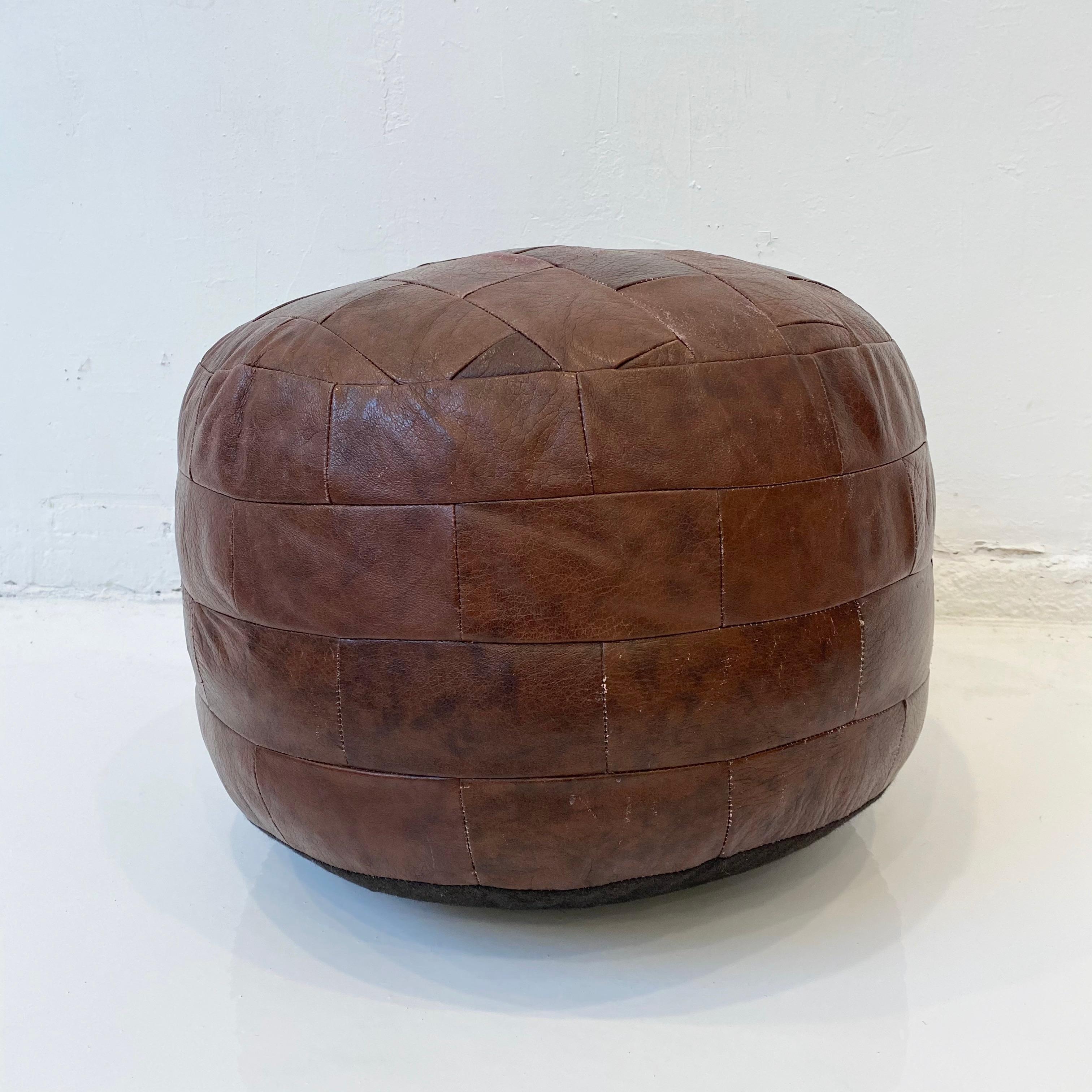 Gorgeous reddish brown patchwork leather pouf by De Sede. Great coloring and patina to leather with various browns. Perfect accent piece.

   