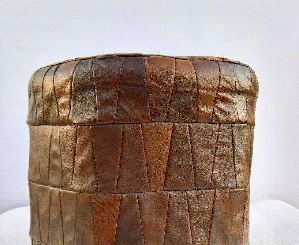 Gorgeous patchwork leather ottoman by De Sede in brown. Cylinder shape with brown leather in slightly varying colors. Great coloring and patina to leather. Very good condition. Great accent piece. 

6-7 ottomans and beanbags by De Sede in our