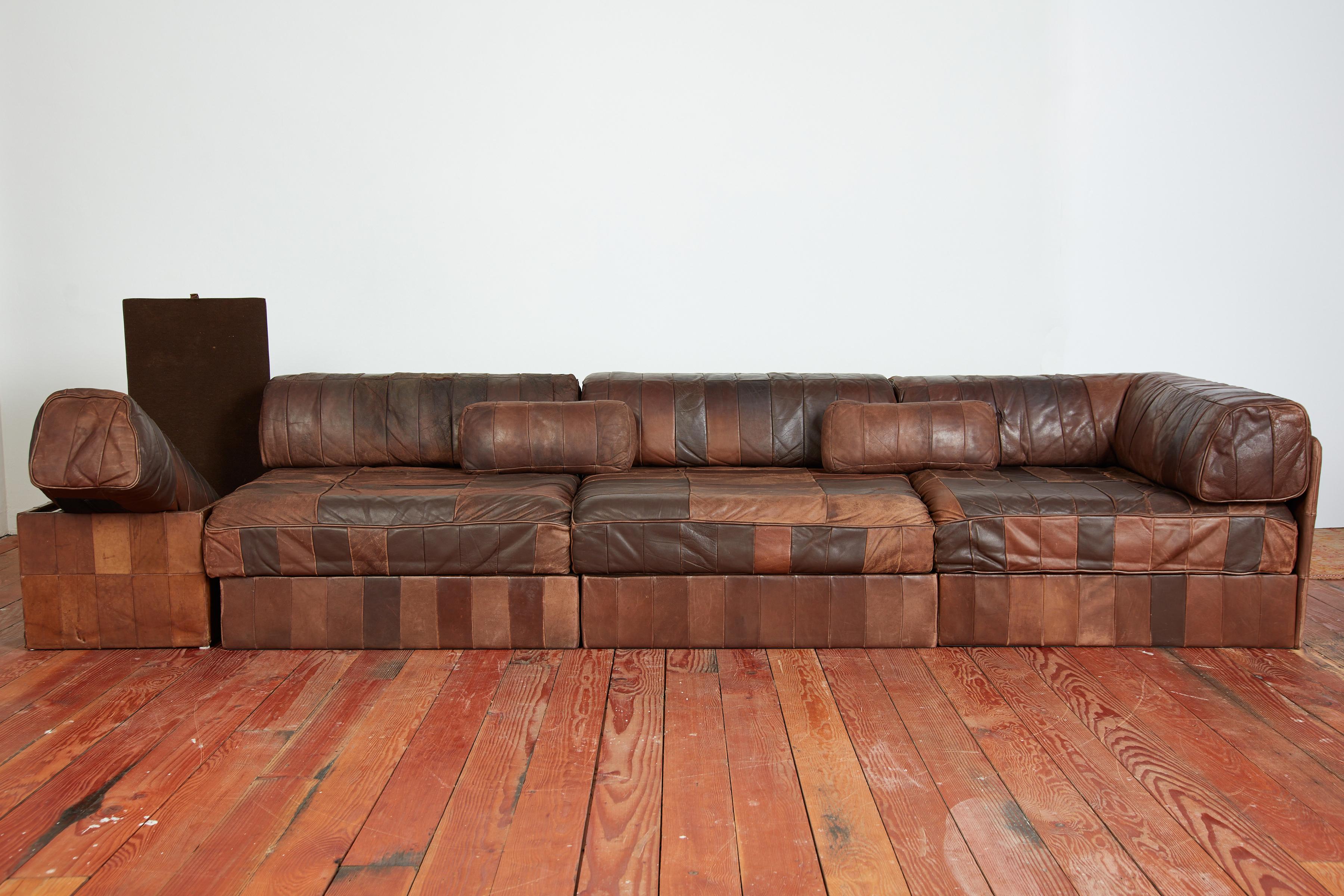 Leather patchwork De Sede modular sectional - Switzerland, 1970s
Original chocolate brown patchwork leather

Comprising of a corner section and two armless sections with removable backrests ( 24