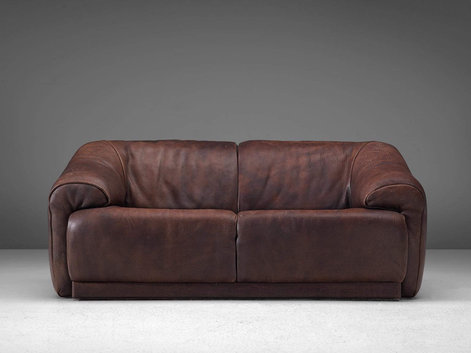 De Sede, two-seat sofa, leather, Switzerland, 1970s.

Highly comfortable sofa in light cognac leather by De Sede. The design is simplistic, yet very modern. It's an early model that is not in production anymore, and it has close similarities to the