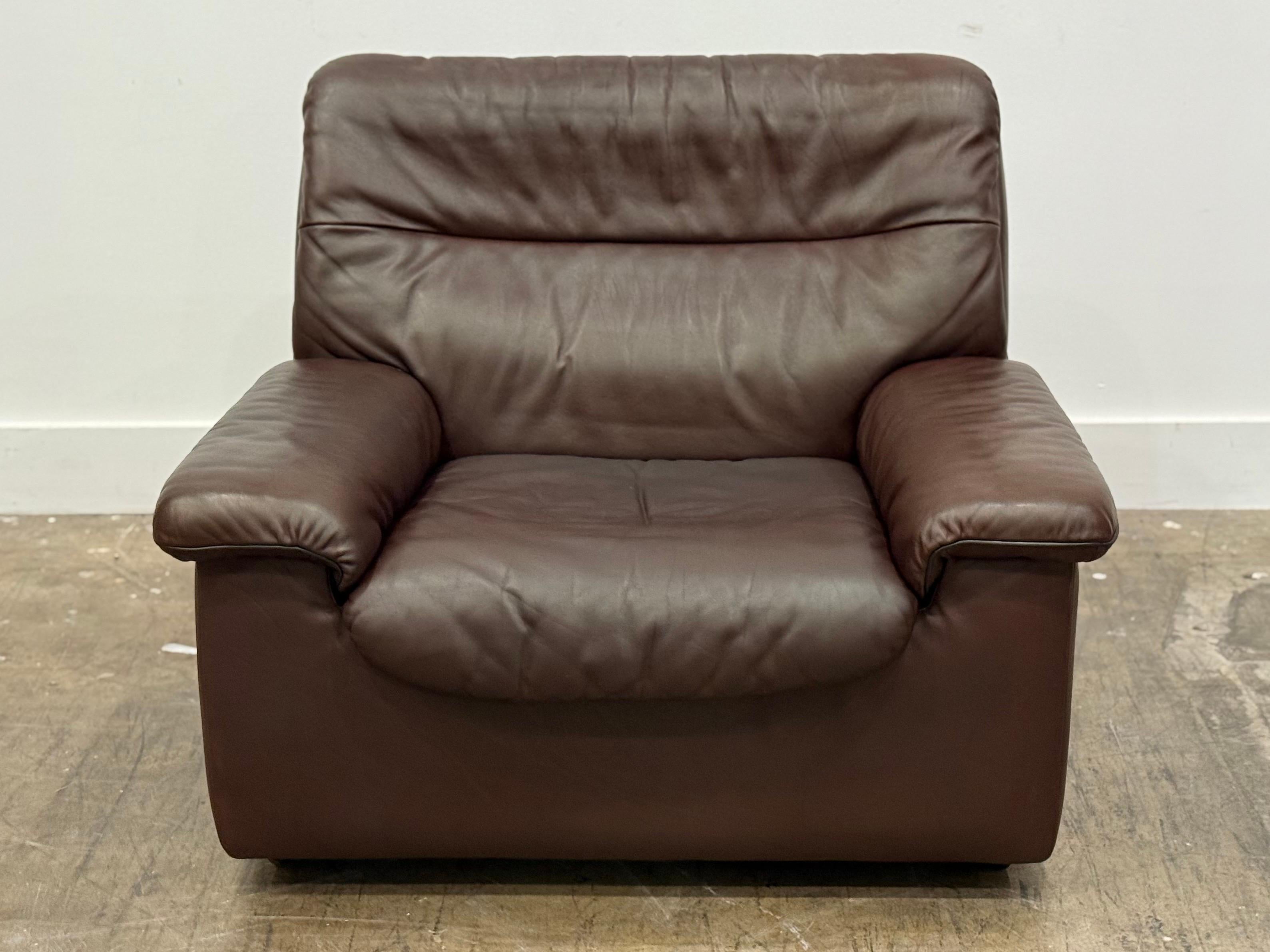 Vintage De sede model ds 63 lounge chair in patinated chocolate brown leather, Switzerland circa 1970s. This De Sede lounge chair ensures ultimate comfort and build quality with its solid wooden frame and thick hand-stitched leather upholstery. 
The