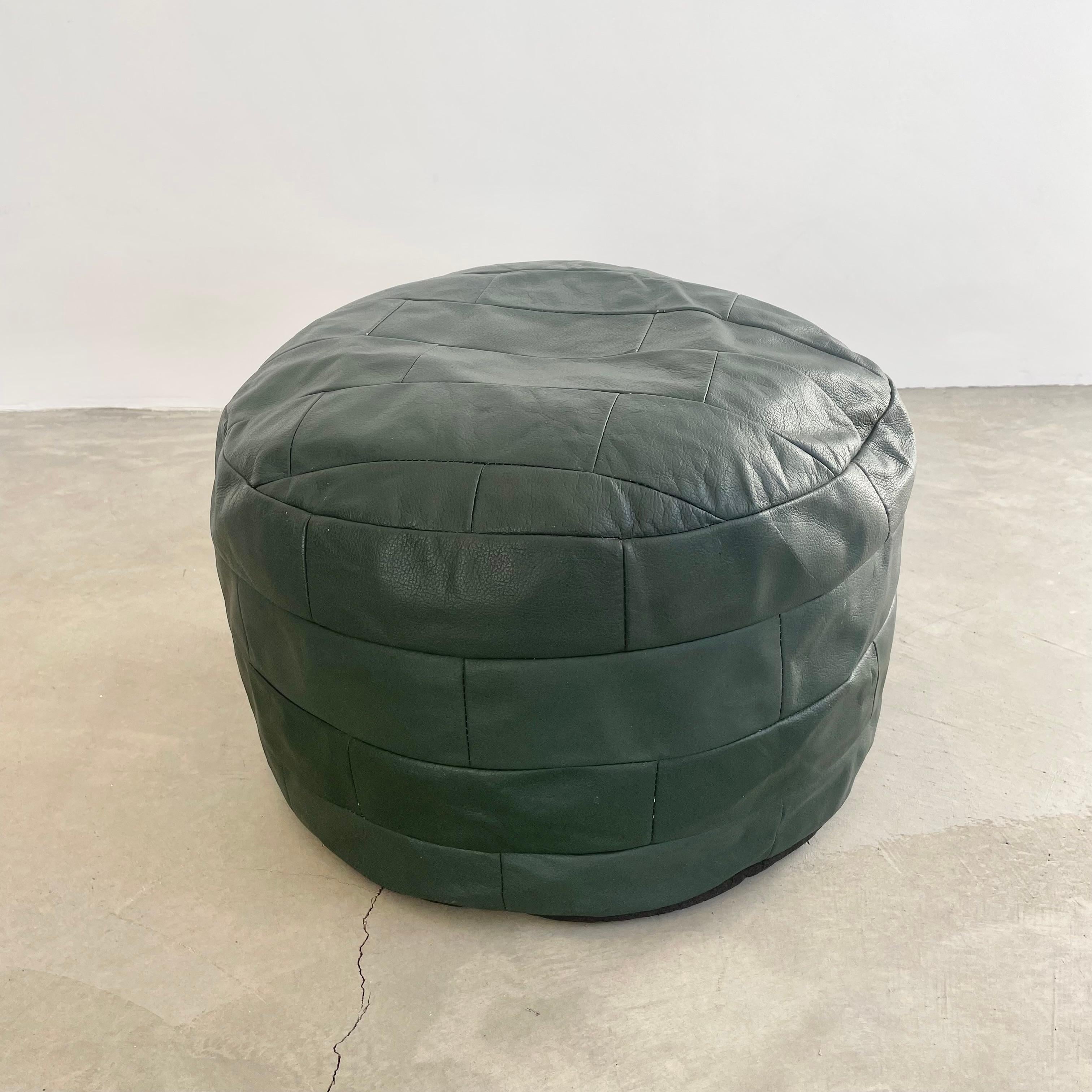 Gorgeous viridian green leather pouf/ottoman by Swiss designer De Sede with square patchwork. Handmade with wonderful faded patina. Gorgeous accent piece. Good vintage condition. Wear appropriate with age. Brand new filler. Perfect living room