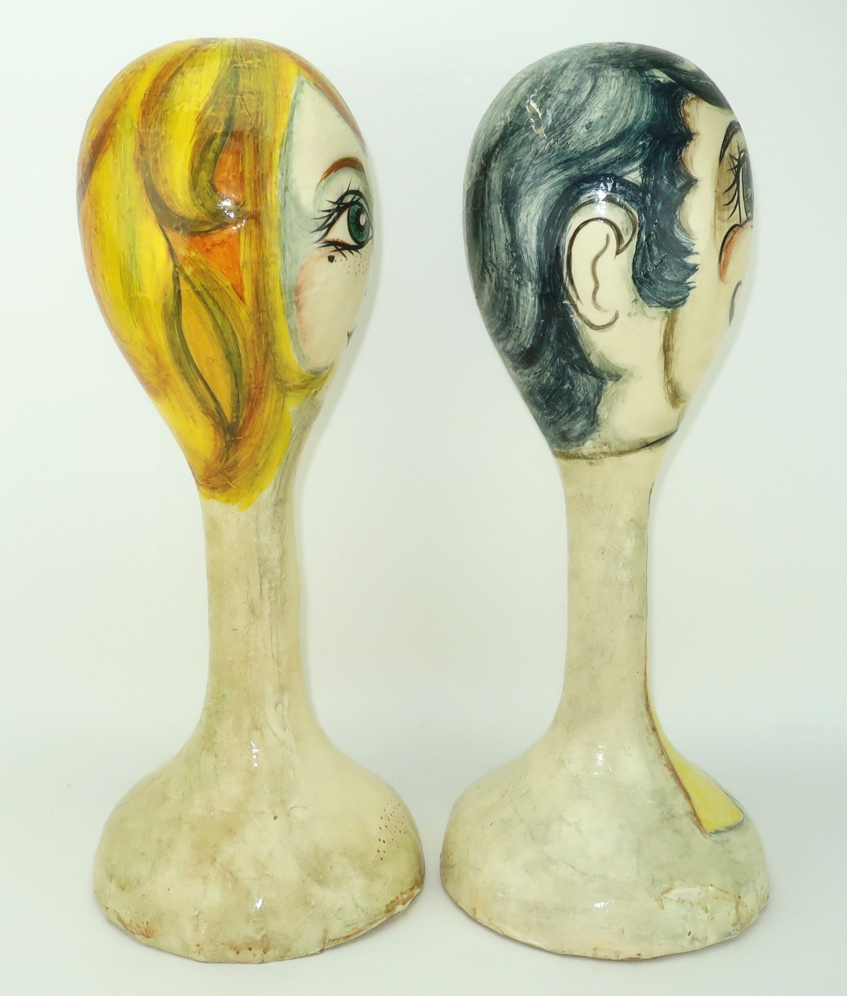 Two heads are better than one! Adorable pair of Mexican folk art papier mache heads by De Sela depicting a glamorous woman and her dapper gentleman. The woman sports a blonde hairdo with sparkling eyes, long lashes and bow lips. The whimsical