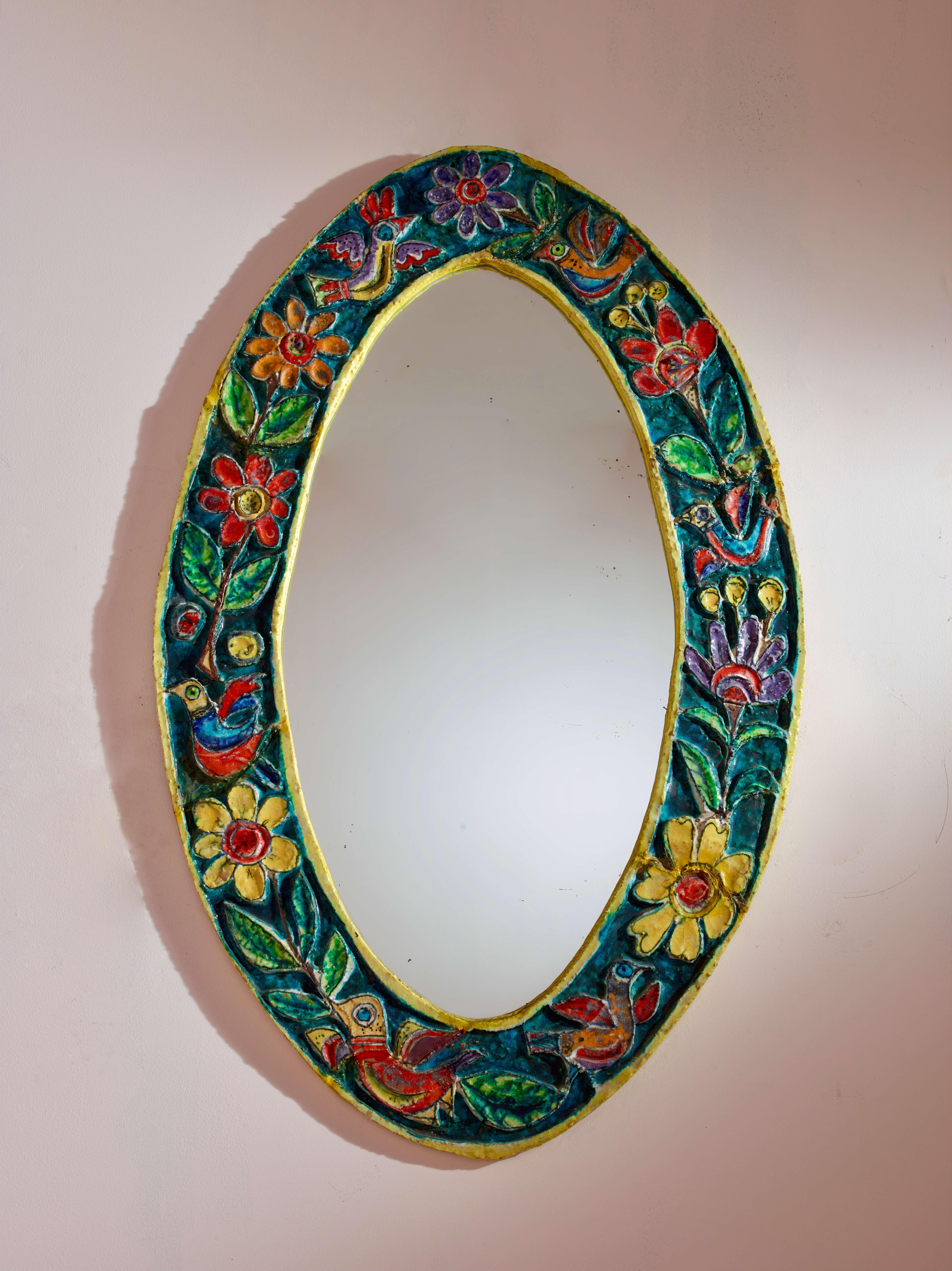 Miroir ovale avec cadre en céramique polychrome, production italienne, artisanat sicilien par Giovanni De Simone, années 1950.

Le goût et la chaleur du sud de l'Italie prennent vie dans ce miroir ovale, doté d'un précieux cadre en majolique peint à