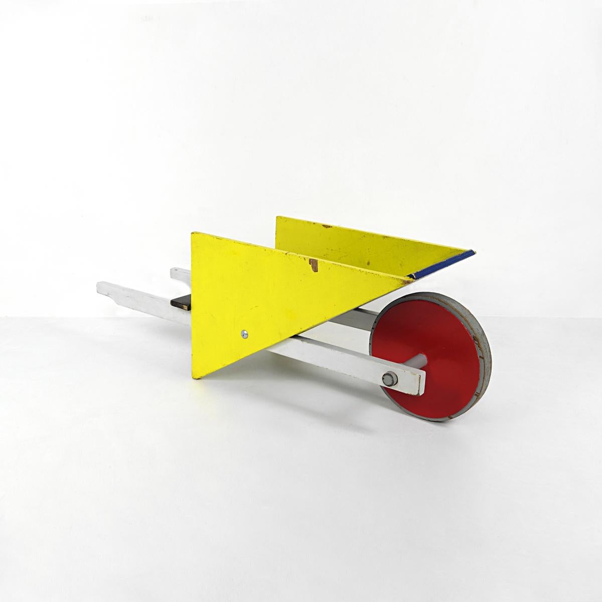 Colorida y alegre carretilla infantil en los colores primarios tan característicos de la obra de Rietveld: rojo, amarillo, azul, negro y blanco.

Esta pieza está todavía en su estado original y no ha sido renovada. Su construcción era sólida y este