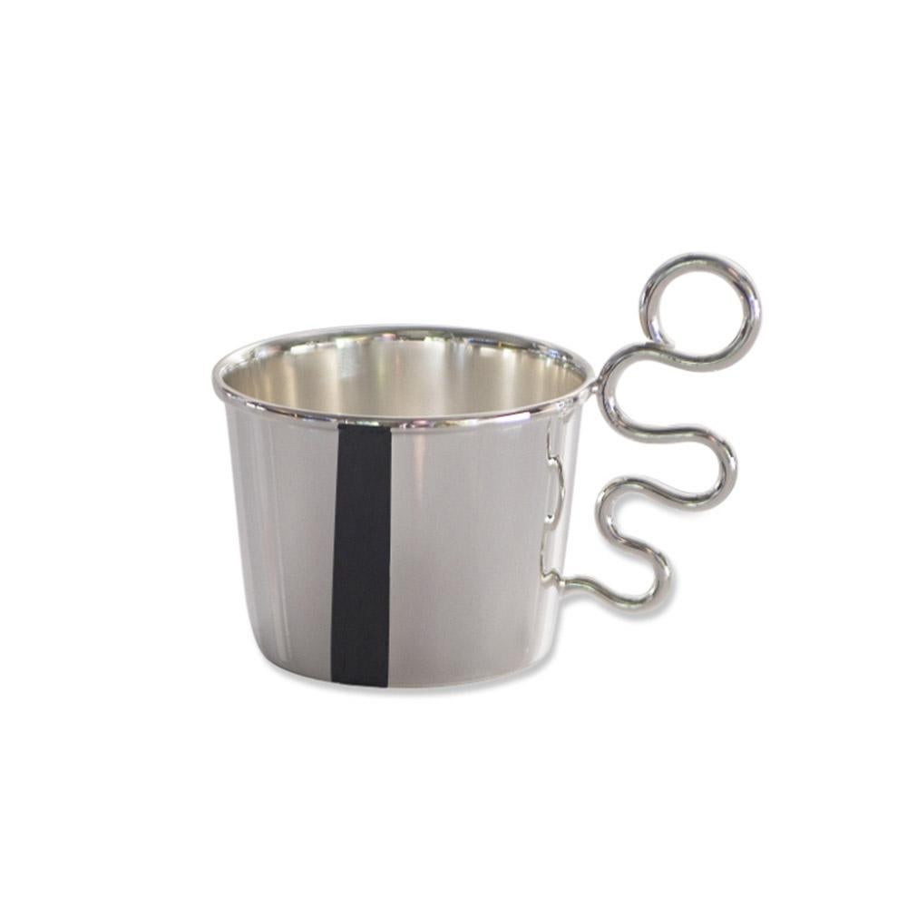 Irony and sinuous forms give birth to a set dedicated to the coffee rite, consisting of cupholder, sugar bowl and tray.

Design: 1980 Gabriele De Vecchi

Porta Tazzina Workaff
Cm 8 x 5 x 5.5 H Gr40
Argento 925°°° / Sterling silver

Porta