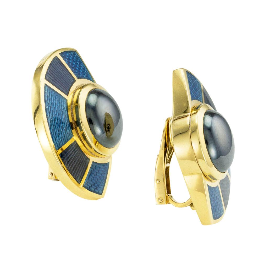 De Vroomen enamel hematite and gold clip-on earrings circa 1988. *

SPECIFICATIONS:

GEMSTONES:   two round, cabochon hematite.

METAL:  18-karat yellow gold decorated by shades of blue enamel.

WEIGHT:  30.2 grams.

EARRING BACKS:  clip