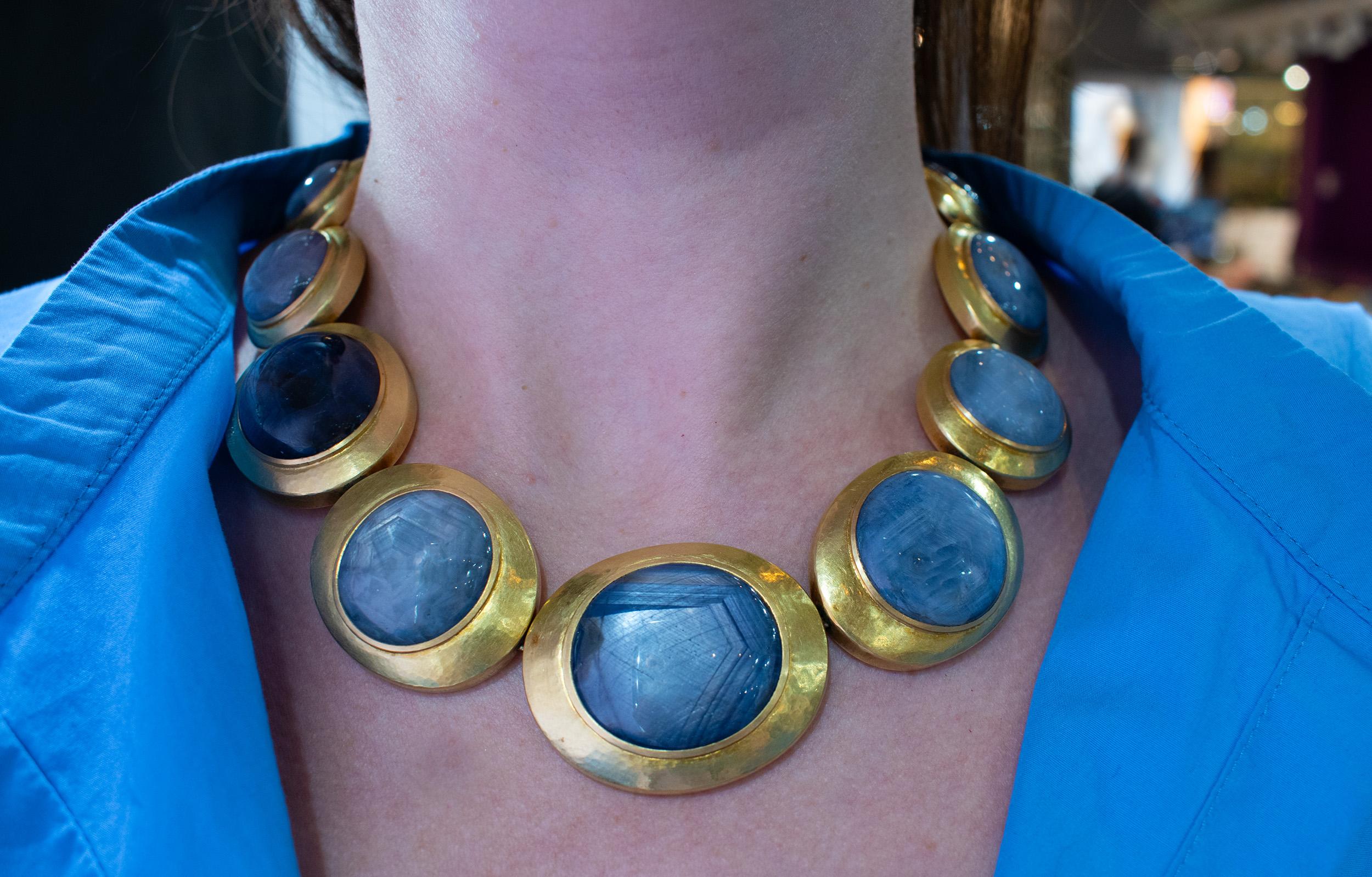 Cette extraordinaire pièce d'apparat présente des saphirs étoilés lumineux sertis dans d'audacieuses montures circulaires en or. D'un poids impressionnant de 256,3 grammes, ce collier respire la prestance et le luxe. Chaque saphir étoilé cabochon