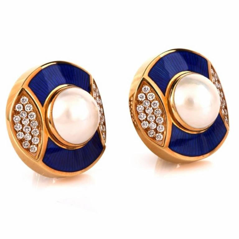 
These Vintage earrings  crafted in solid 18K yellow gold are designed as a pair of circular plaques, centered with a pair of 10mm Mabe pearl flanked by pave diamond swathed. The precious 72 round diamonds weigh cumulatively  1.78 carats and are