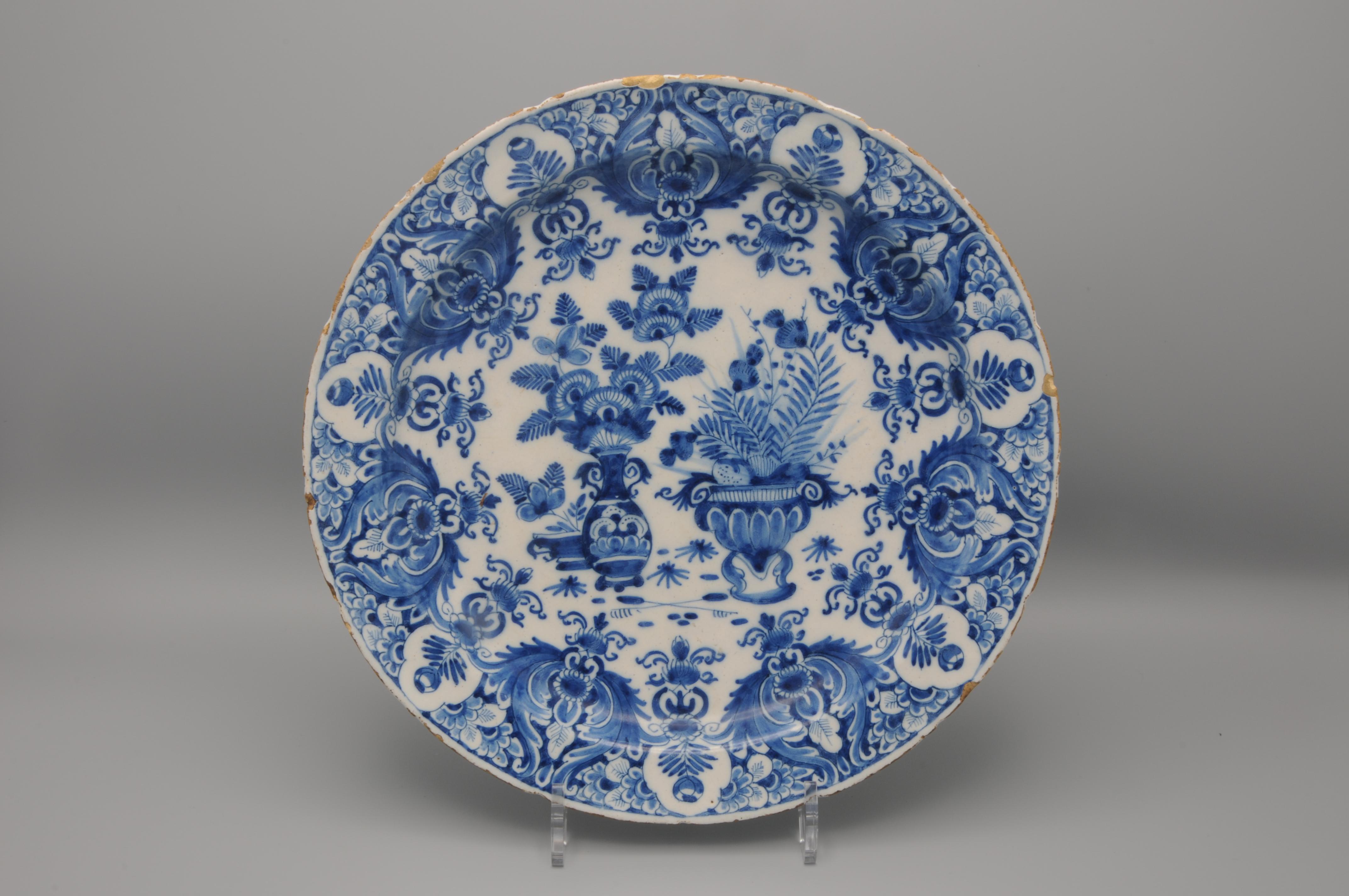Rare early 18th century Blue Delftware plate with elaborate chinoiserie decoration of three flower baskets. Beautiful border decoration of rich foliage, flowers and scrollwork. 

Marked 'De witte Starre', active from 1660 - 1804