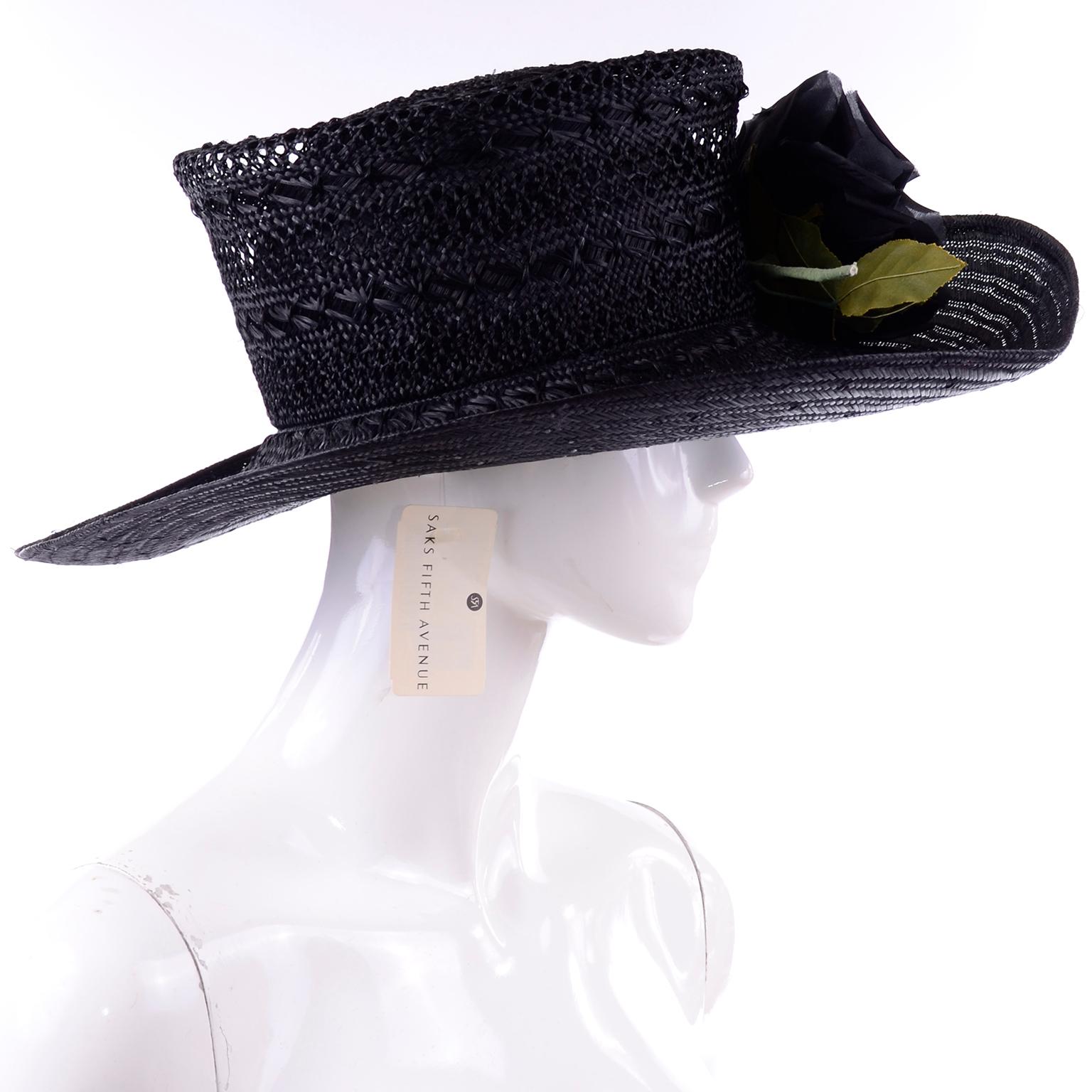 Black straw hat from Saks with the original tag! The top flares out away from the dome piece for a flat circular top. The brim curves up at the edge. 
Head Circumference: 22