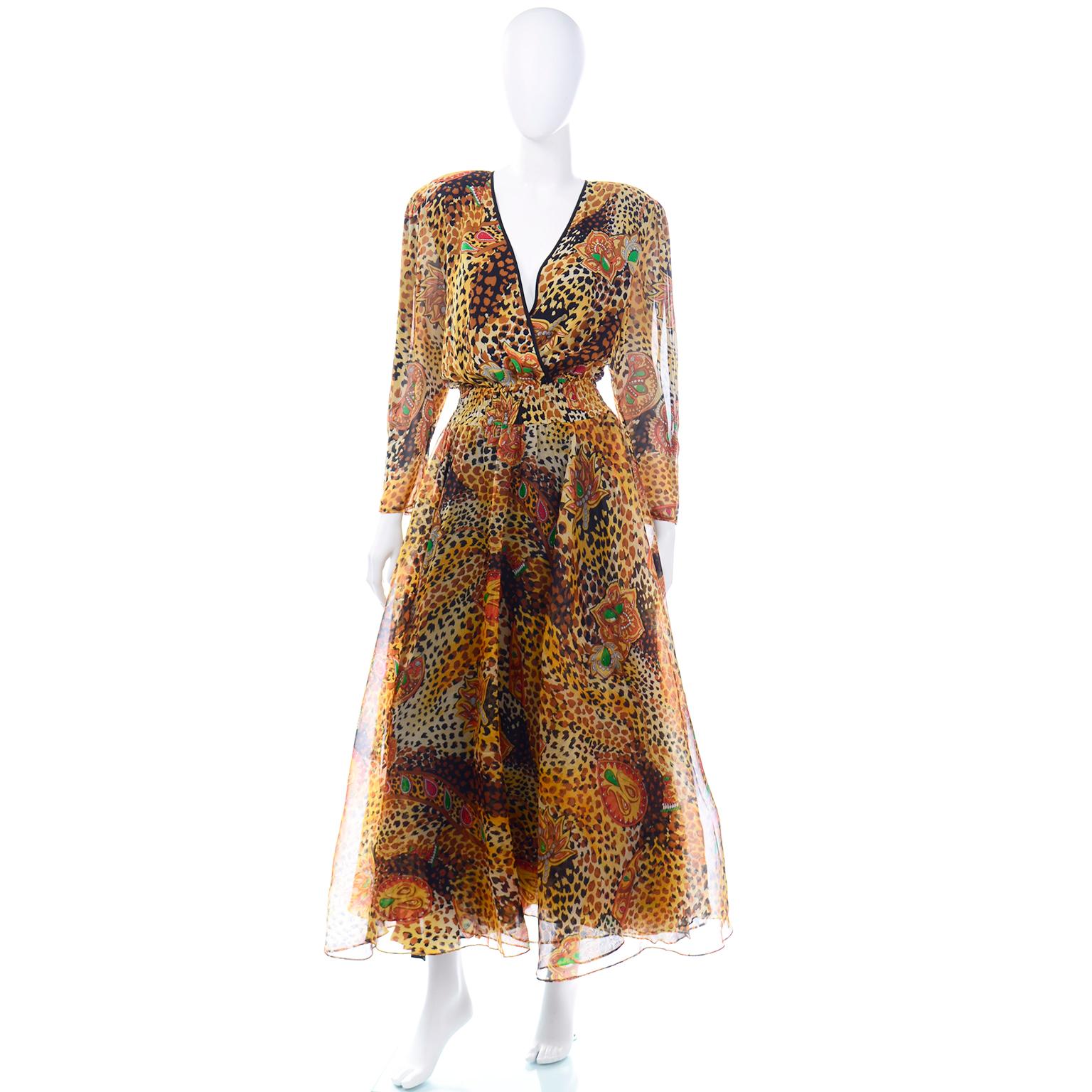 This beautiful vintage Diane Freis dress is made in a brown and black silk animal (cheetah or leopard) print with abstract jewels and leaves in shades of green, red, orange and yellow.  This stunning dress has a low v neckline, full circle skirt and