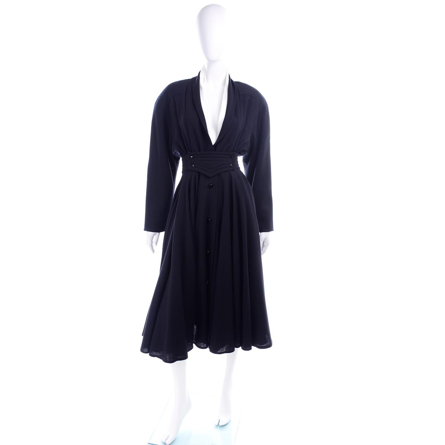 This dress is very hard to capture in photographs, but it is a stunning vintage wool Wayne Clark dress with a full skirt and a cinched waist.  The dress has buttons down the front and a detailed waist accentuated with a wide waistband and buttons. 