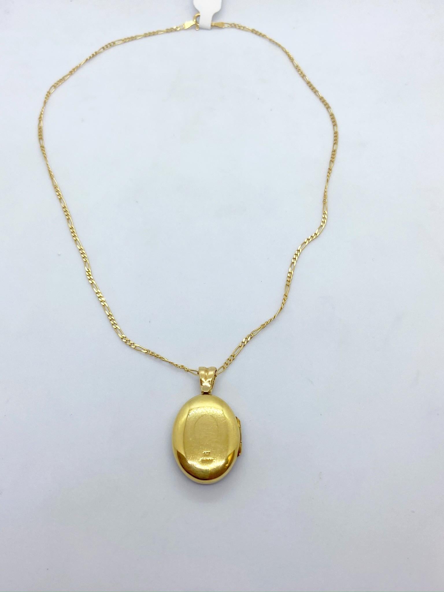 18 karat yellow gold locket crafted by Deakin & Francis, England's oldest family jewelers since 1786.
The oval locket's front is a guicholled navy blue enamel. The center has a gold starburst motif set with round brilliant Diamonds. The back is a