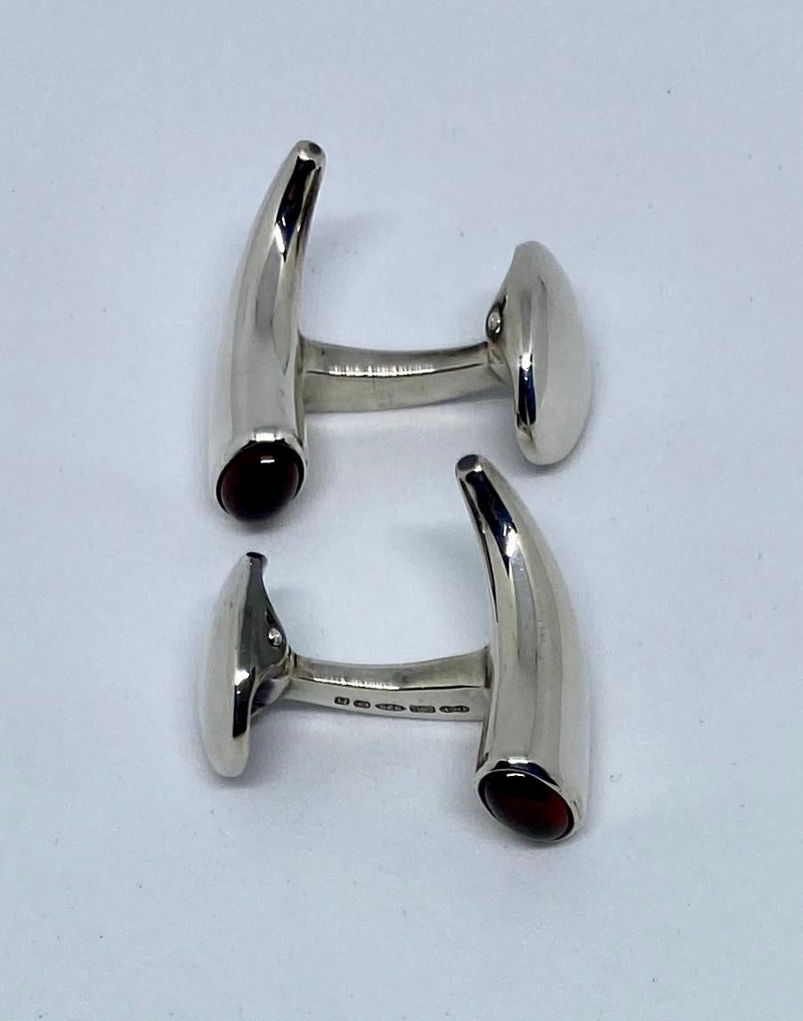 These classic English cufflinks in sterling silver each feature a deep, red cabochon-cut garnet on one end of the horn-shaped face.

Founded in 1786, Deakin & Francis has been operated by the same family for two and a half centuries. The quality and