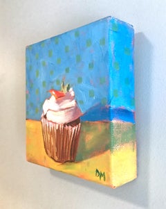 "Small Cupcake with White Frosting and Cherry on Blue and Yellow Background"