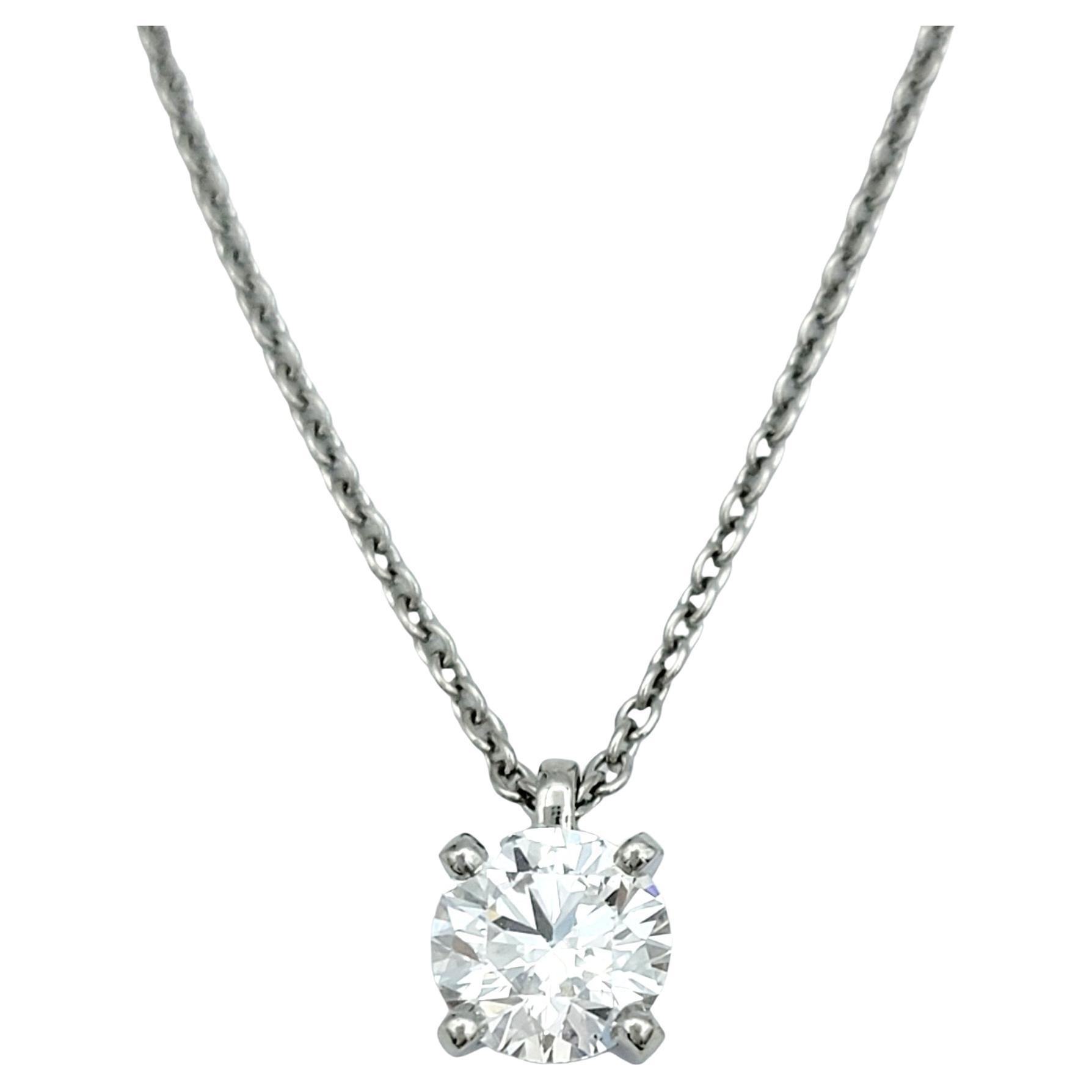 This stunning De Beers Classic diamond solitaire necklace is a symbol of refined elegance and timeless beauty. Set in luxurious polished platinum, the pendant features a dazzling .59 carat round brilliant cut diamond, meticulously chosen for its