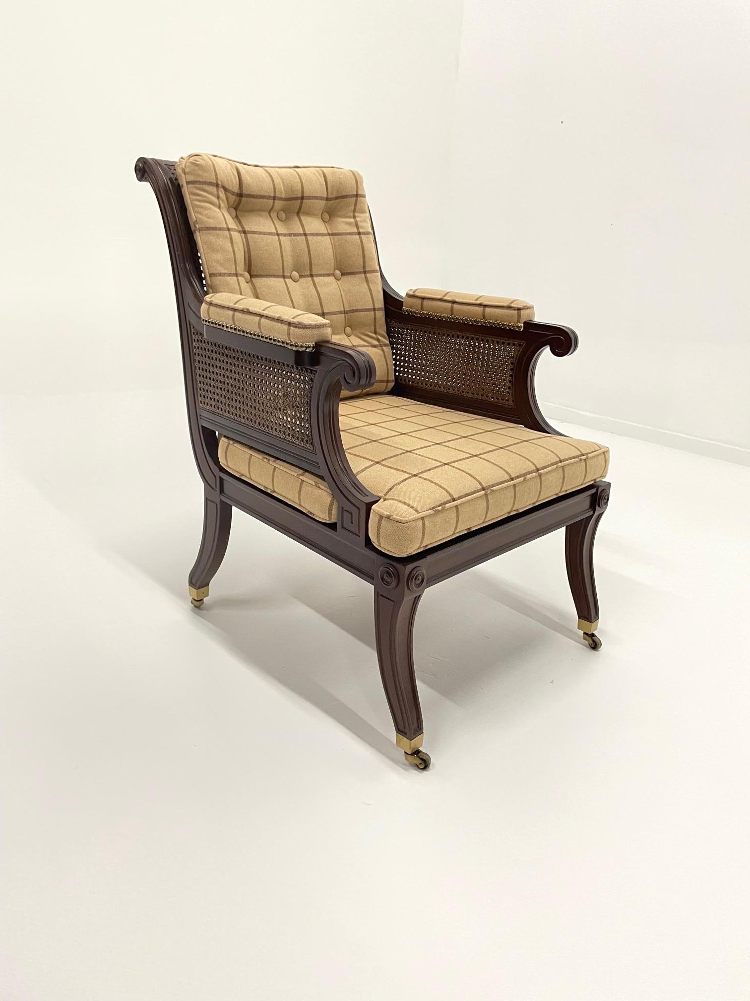 Handsome mahogany club chair by Baker having caned back with buttons and stylish wool suiting fabric camel plaid upholstery. Great details like caning on the arms and upholstered arm rests, curved legs that terminate in brass casters.
arm height