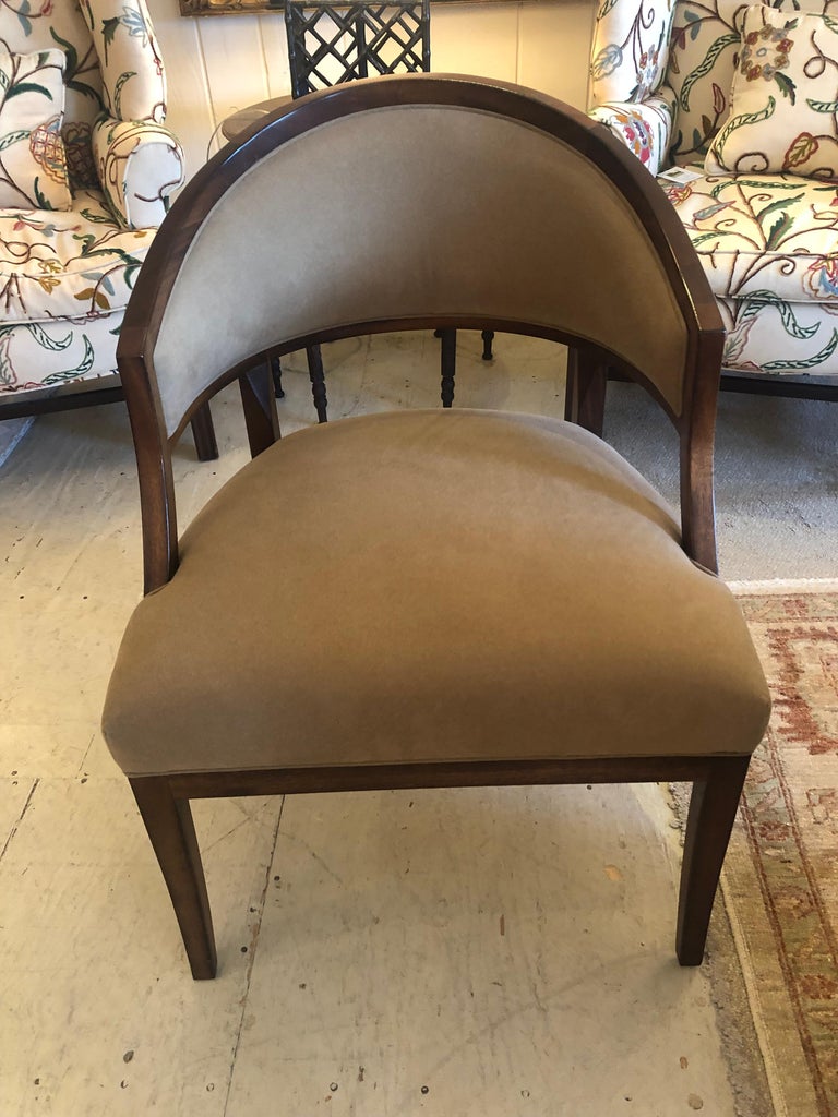 Handsome pair of curved traditional walnut and upholstered club chairs in a neutral versatile soft camel or taupe faux suede fabric. Color looks different depending on the light.