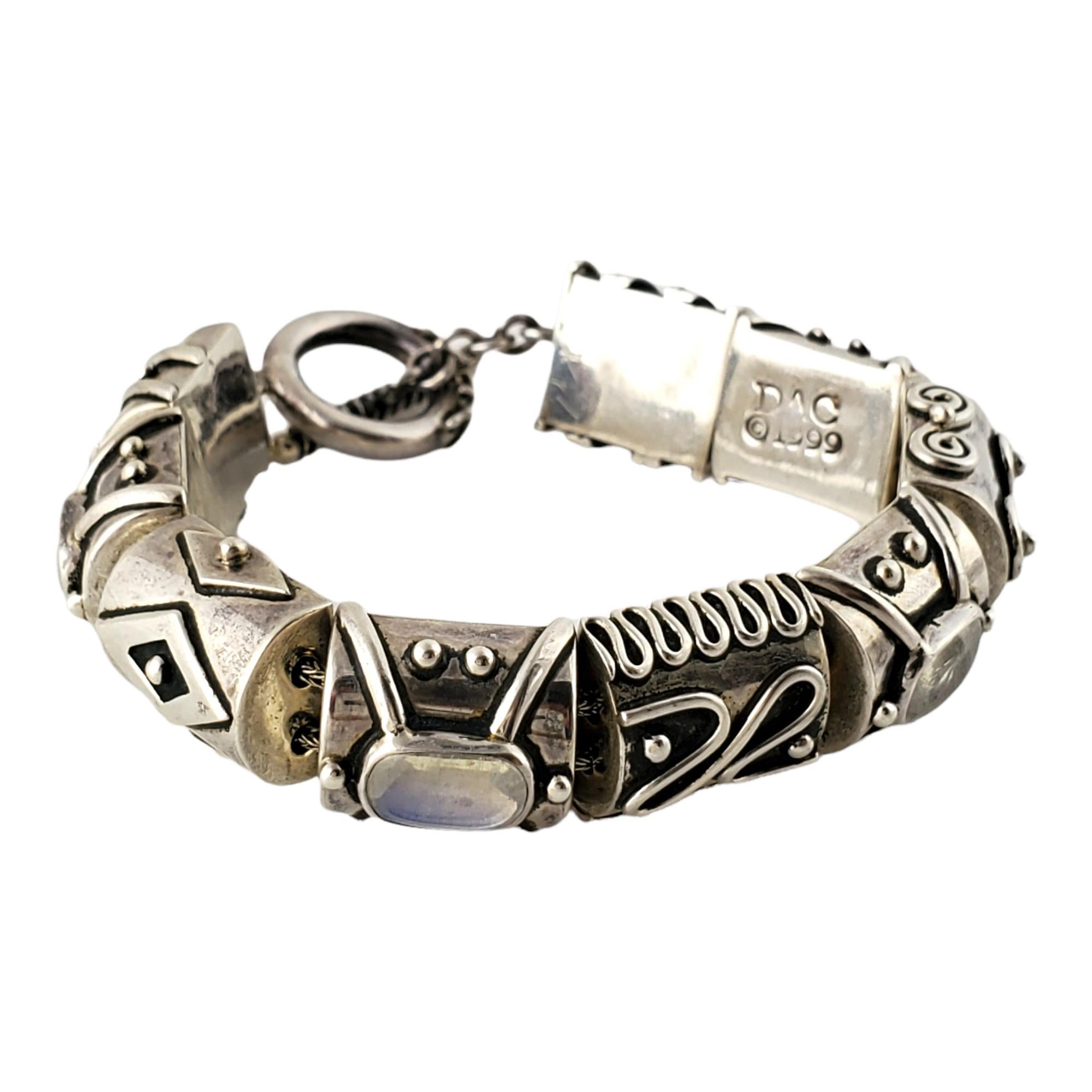 Sterling Silber und schillernden Stein Toggle Armband von Deborah Armstrong

Dieses Stück enthält  9 klobige Perlen mit verschiedenen Designs, 4 Perlen mit ovalen, schillernden Cabochon-Steinen. Texturierter Knebelverschluss.

Misst ca. 8