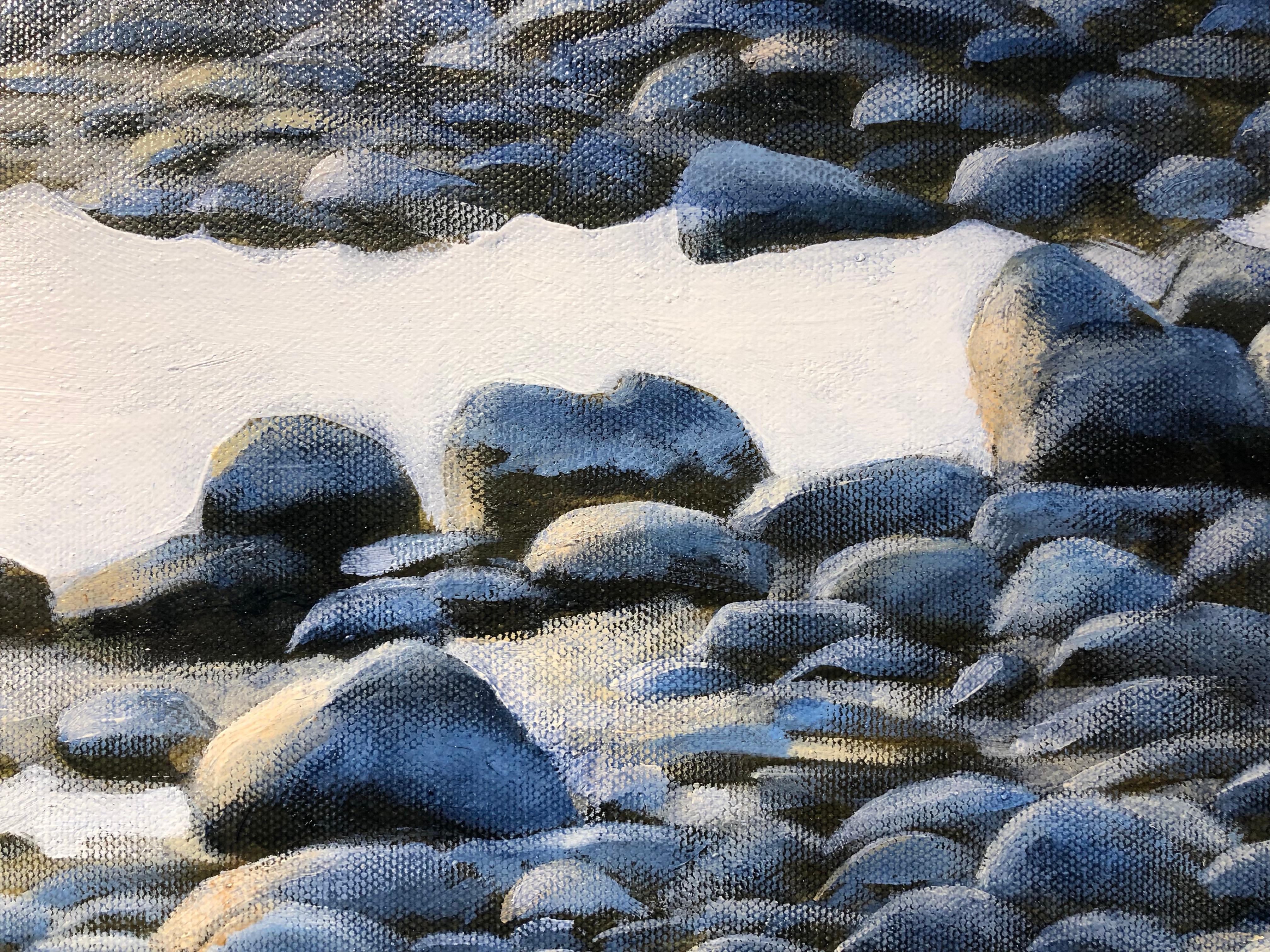 This oil on canvas painting of blue gray rocks and water lapping at the shore is beautifully painted in a representational style.  Upon close examination the brush strokes show an influence of impressionism.  The scene is saturated with bright