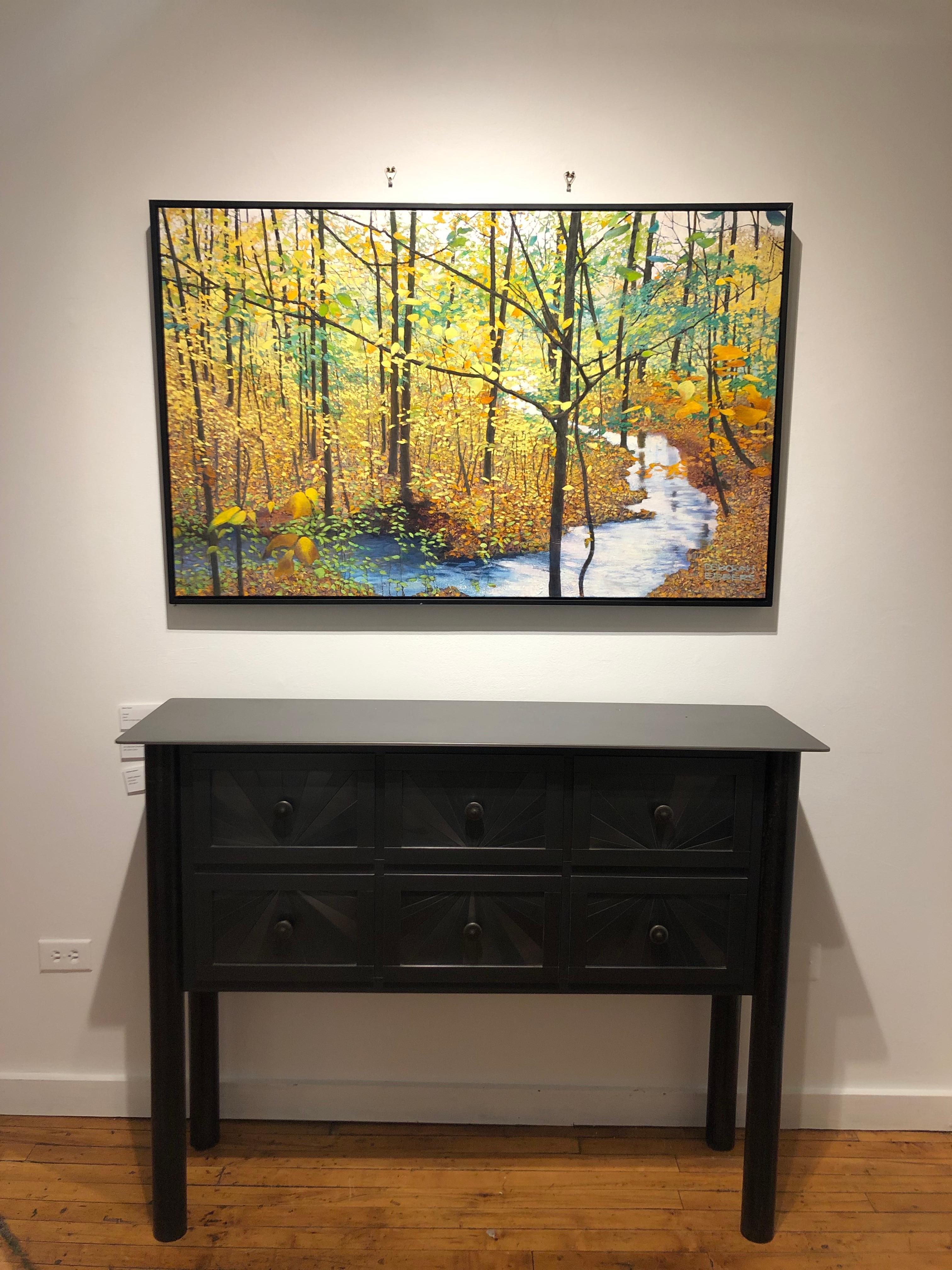 Along Lake Michigan's northern shore, the setting sun casts its golden shimmer into the woods.  The trees and leaves  come alive with radiance in this original oil painting by Deborah Ebbers.  This pristine, secluded spot near the artist's home