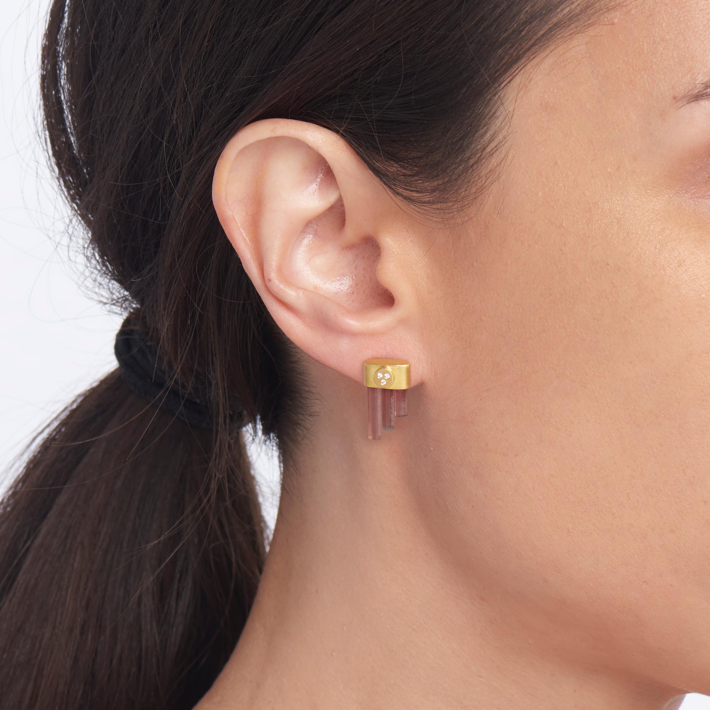 Three lovely pink tourmaline crystals are wrapped in a 22 karat yellow bezel accented with tiny white diamonds.  These charming one-of-a-kind drop earrings are a fresh and contemporary way to grace your ears.  The 18 karat yellow gold posts and