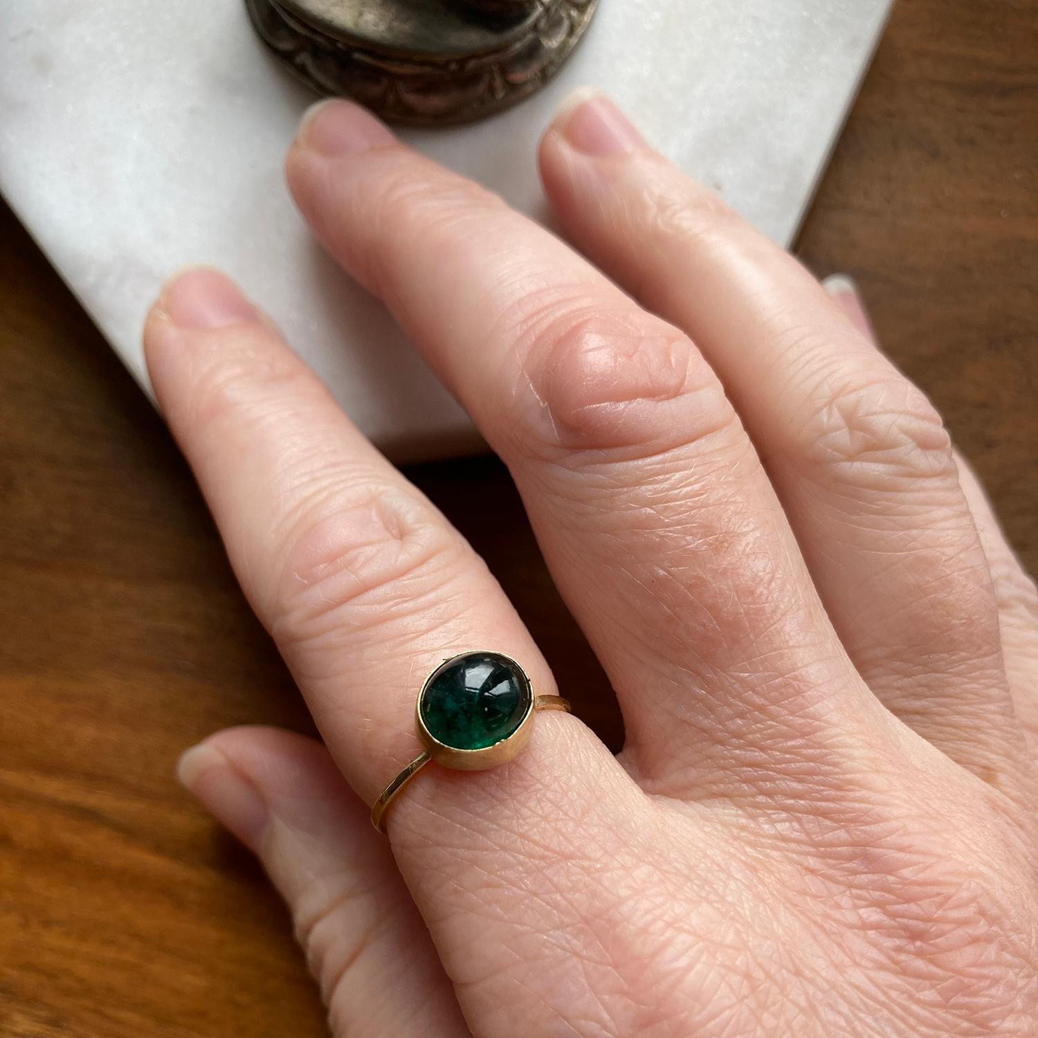 18 Karat Yellow Gold Love Knot Ring by Deborah Murdoch featuring a unique oval Green Emerald Cabochon Stone. The ring band has an organic knot giving the option of showing the emerald stone or the knot at the front.

Metal: 18 Karat Yellow