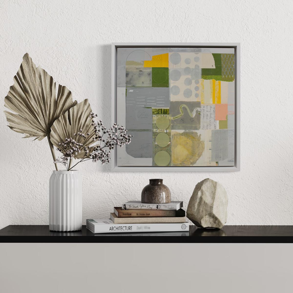 Este cuadro collage abstracto de Deborah T. Colter está realizado con pintura acrílica y elementos de collage de técnica mixta sobre panel. Presenta una paleta de grises y verdes con cálidos toques de amarillo dorado y rosa. La composición es