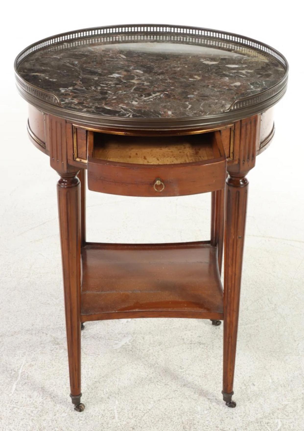 French Directoire bouillotte side table or gueridon from De Bournaise. Solid brass sabots with castors along with drawer pull and pierced gallery. Factory applied distress and aging. A fantastic little table that can fit seemlessly into many types