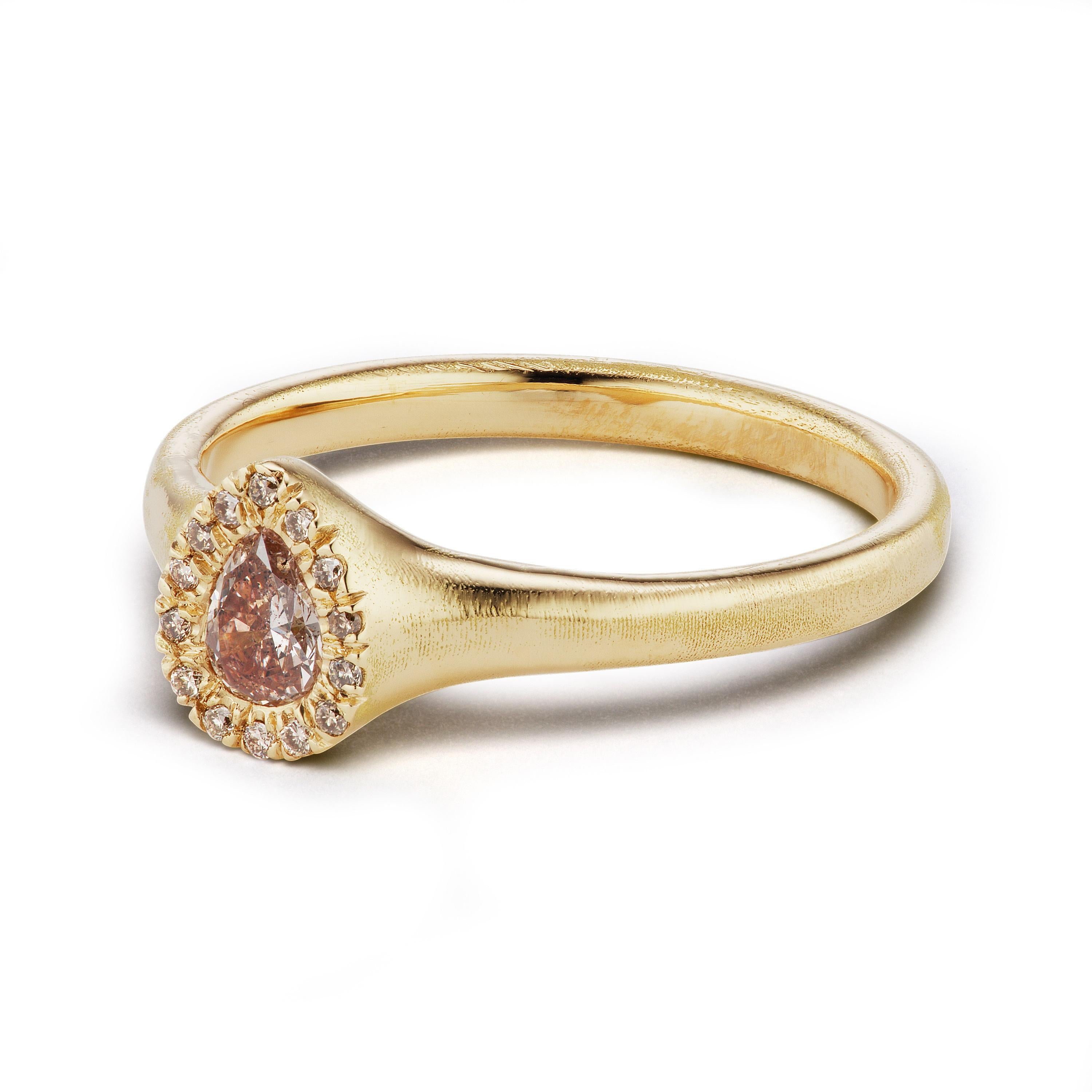 The Pebble Halo ring, from our Barefoot Collection, is hand-crafted with 18-karat recycled yellow gold, and features one pear shape, natural pink color diamond, and 14 champagne accent diamonds in the halo. The Pebble Halo ring would lend itself