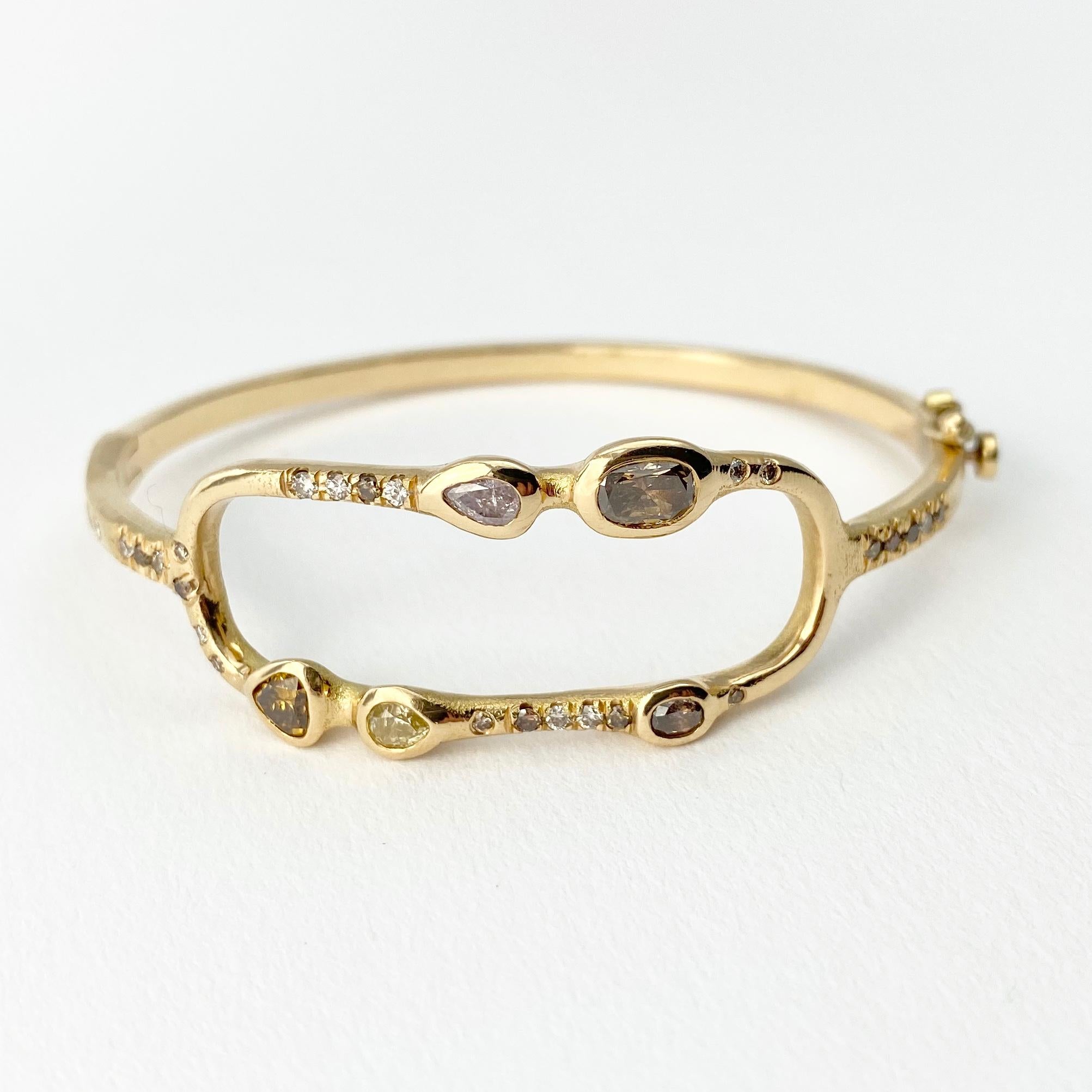 The Pathway bangle bracelet, from our Barefoot Collection, is hand-crafted with 18-karat recycled yellow gold, and features five bezel-set colored diamonds (three pear shape, and two oval),; and 27 round champagne accent diamonds. Finished with a