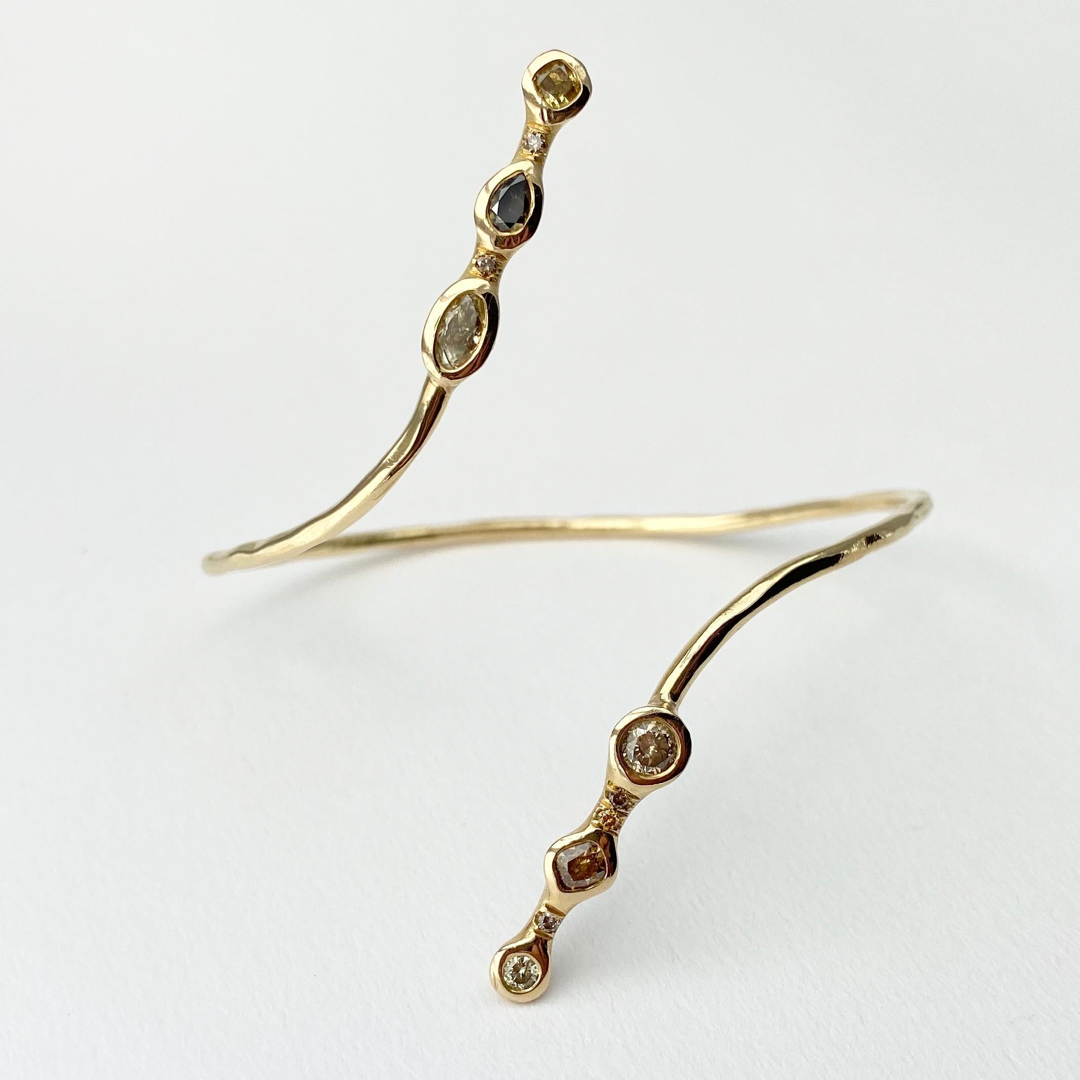 The Meander bracelet, form our Barefoot Collection, is hand-made with 18-karat recycled yellow gold, and features six bezel set, colored diamonds (two cushion shape, two round, one pear, and one oval); and five round, champagne accent diamonds. This