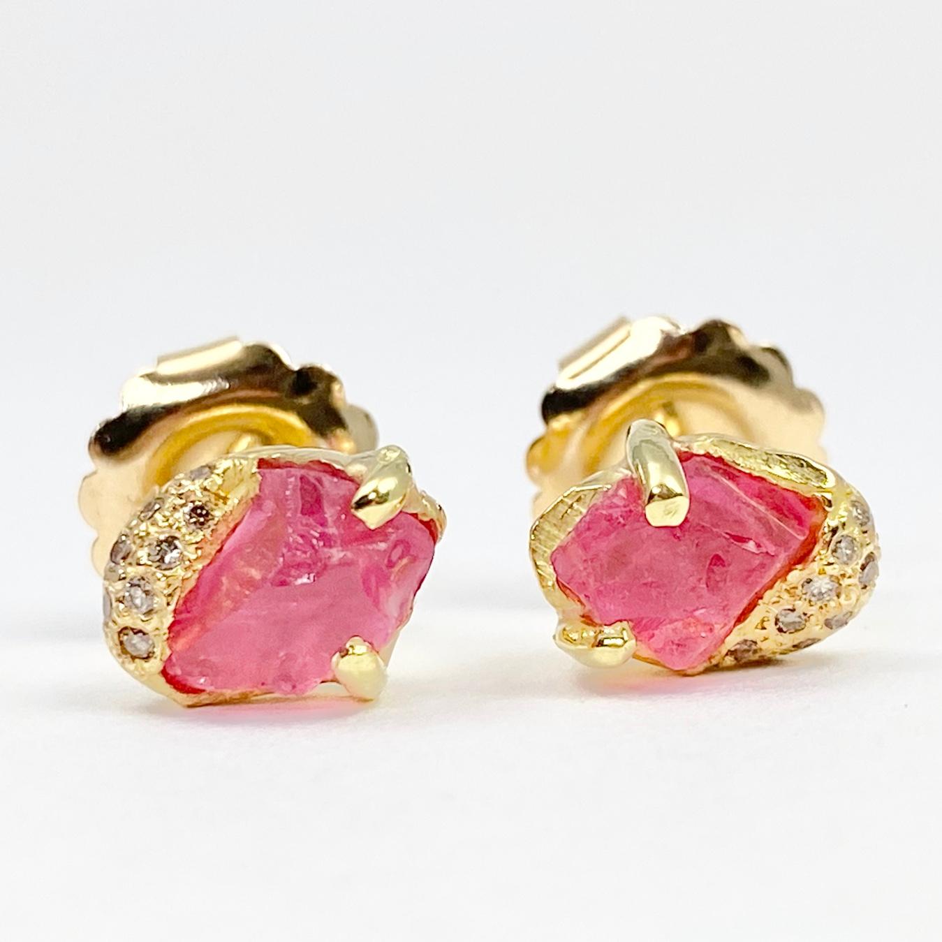 This pair of Pia stud earrings is hand-crafted with 18-karat recycled yellow gold, and features two untreated, Tenda Cut, natural color pink spinel; and 17 round champagne accent diamonds. The Pia stud is hand-made to accommodate each unique