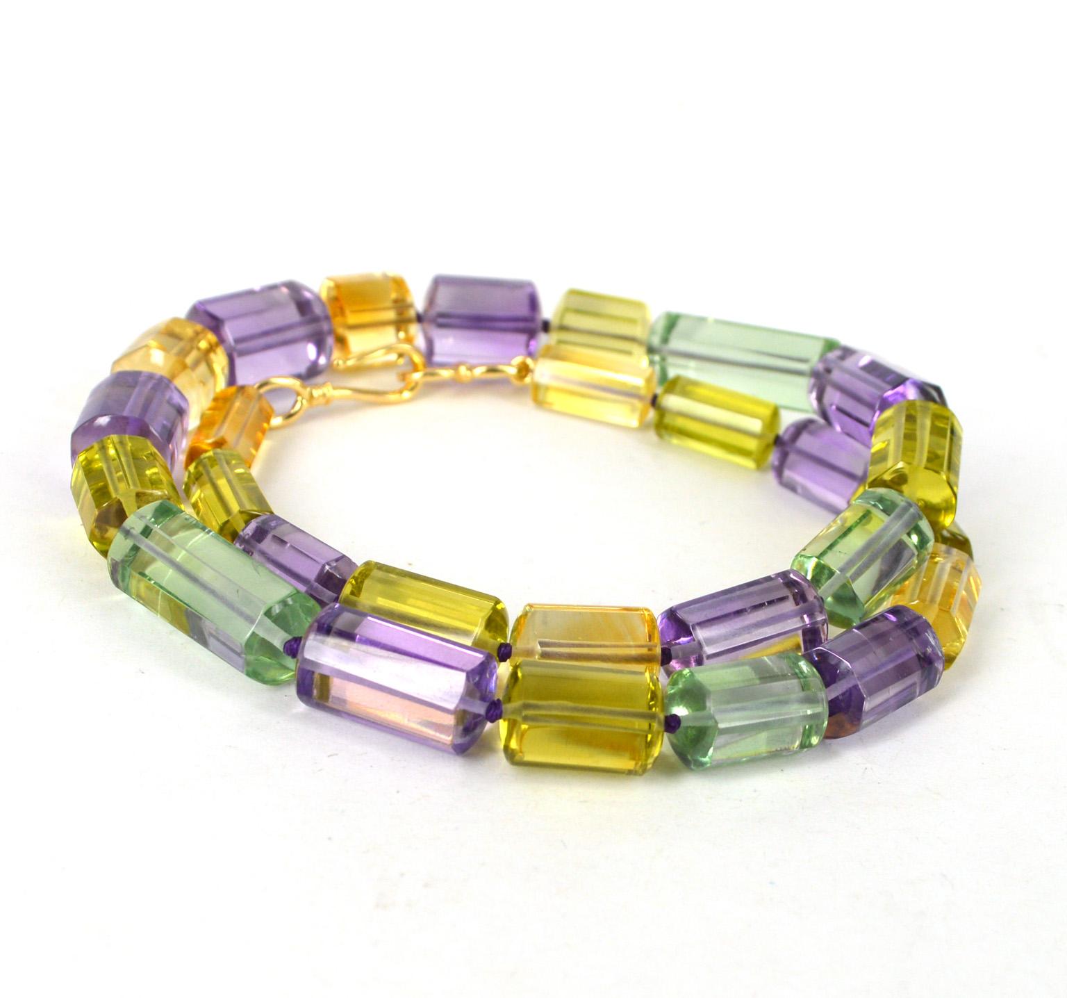 High quality polished 8 sided tube beads of Amethyst, Green Amethyst, Lemon Quartz and Citrine hand knotted on purple thread. Tubes graduate from 15x7mm with the center bead 16.6x11mm. 
24ct Gold Plate Hook Clasp
