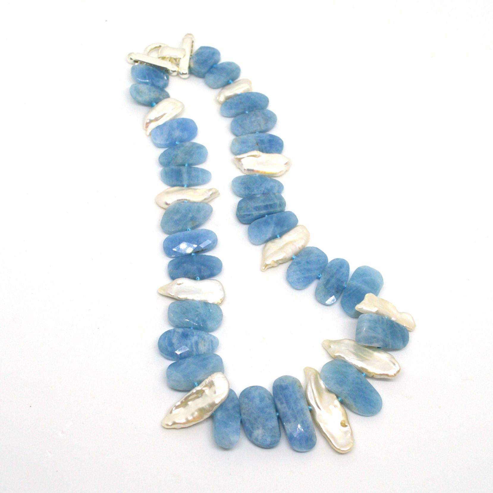 Aquamarine flat faceted centre drilled nuggets approximately 20mm wide with centre drilled keshi freshwater pearls. Hand knotted on matching aqua thread with a sterling silver clasp.
Finished necklace measures 46cm 