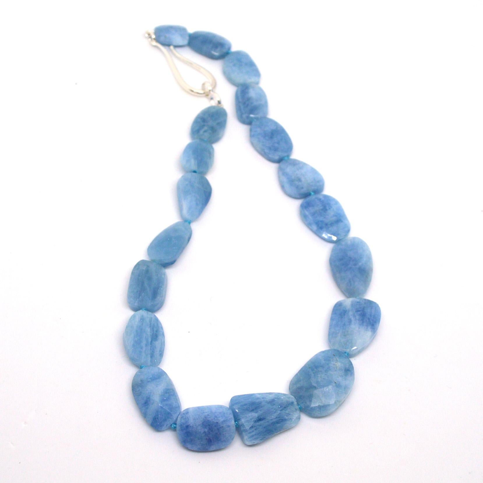 Aquamarine flat faceted nuggets graduated from 15mm to 25mm and there are 19 stones. Hand knotted on matching aqua thread with a 55mm sterling silver hook clasp.
Finished necklace measures 48cm 
