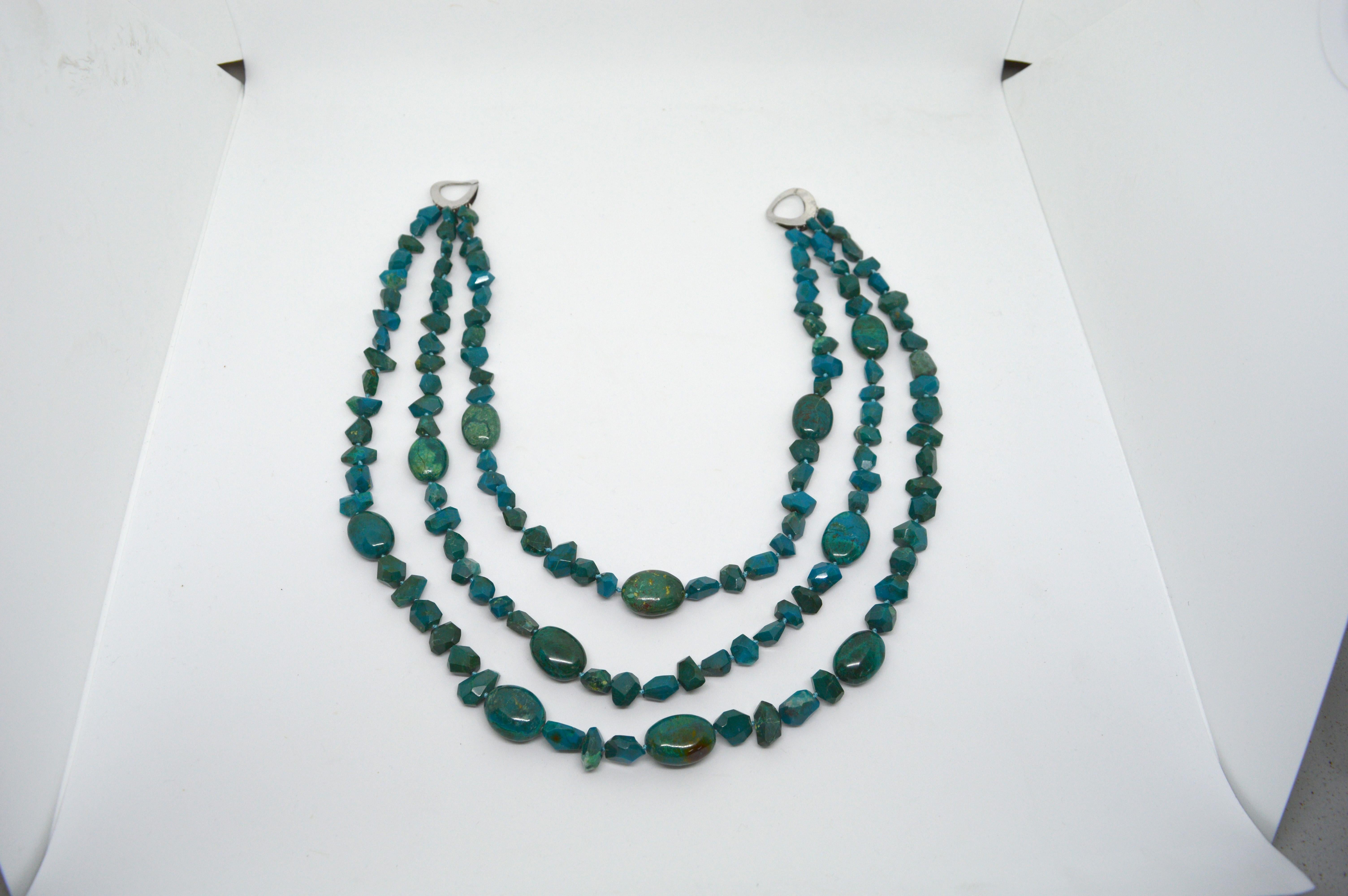 Chrysocolla 23mm nuggets and faceted nuggets make up this impressive necklace.
Graduating strands from 52cm to 66cm with  Sterling Silver slide Clasp.
Hand knotted for strength and durability 
Finished necklace is 66cm.


