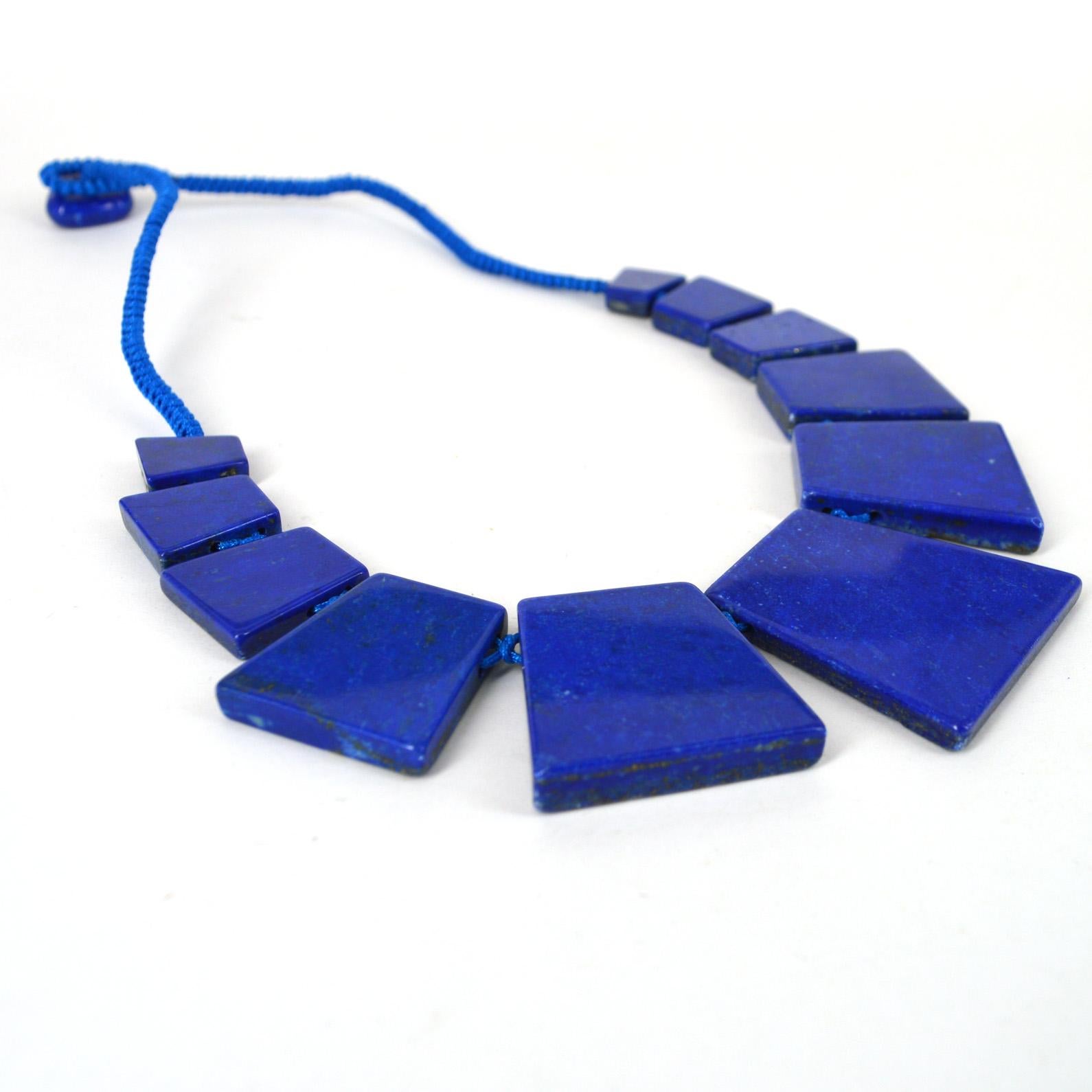 High Quality large natural Graduated Trapezoid Lapis Lazuli knotted necklace with a button Lapis Lazuli clasp. Beads Range from 15-42mm high and the stones are 6mm thick .

Total necklace length 52mm.