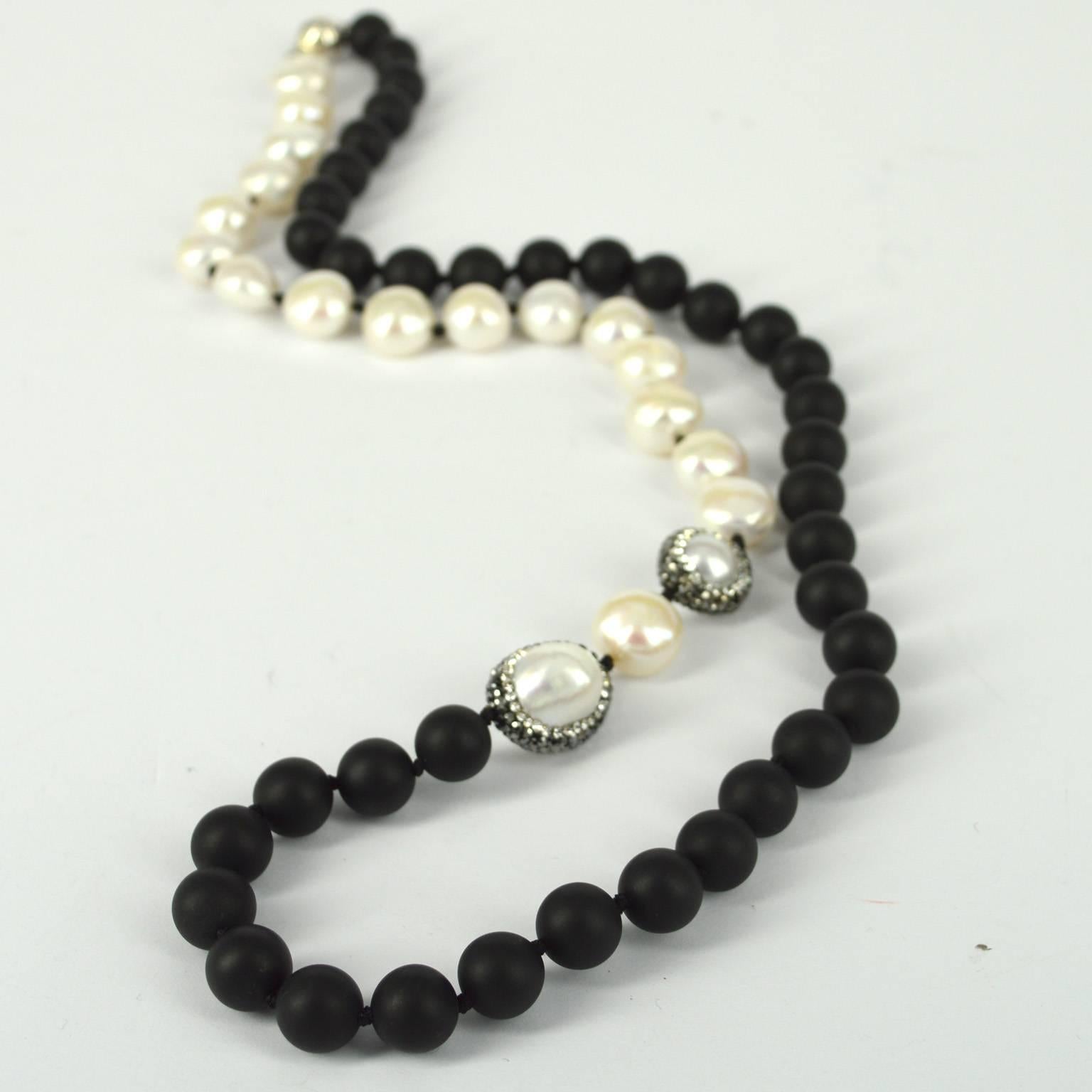 10mm matt black Onyx beads with 12mm Fresh Water Pearls and 2 feature Fresh Water Pearls pave set with crystals measuring 14mm and 12x20mm, hand knotted on black thread and finished with a 10mm Sterling silver clasp.
Finished necklace measures 74cm