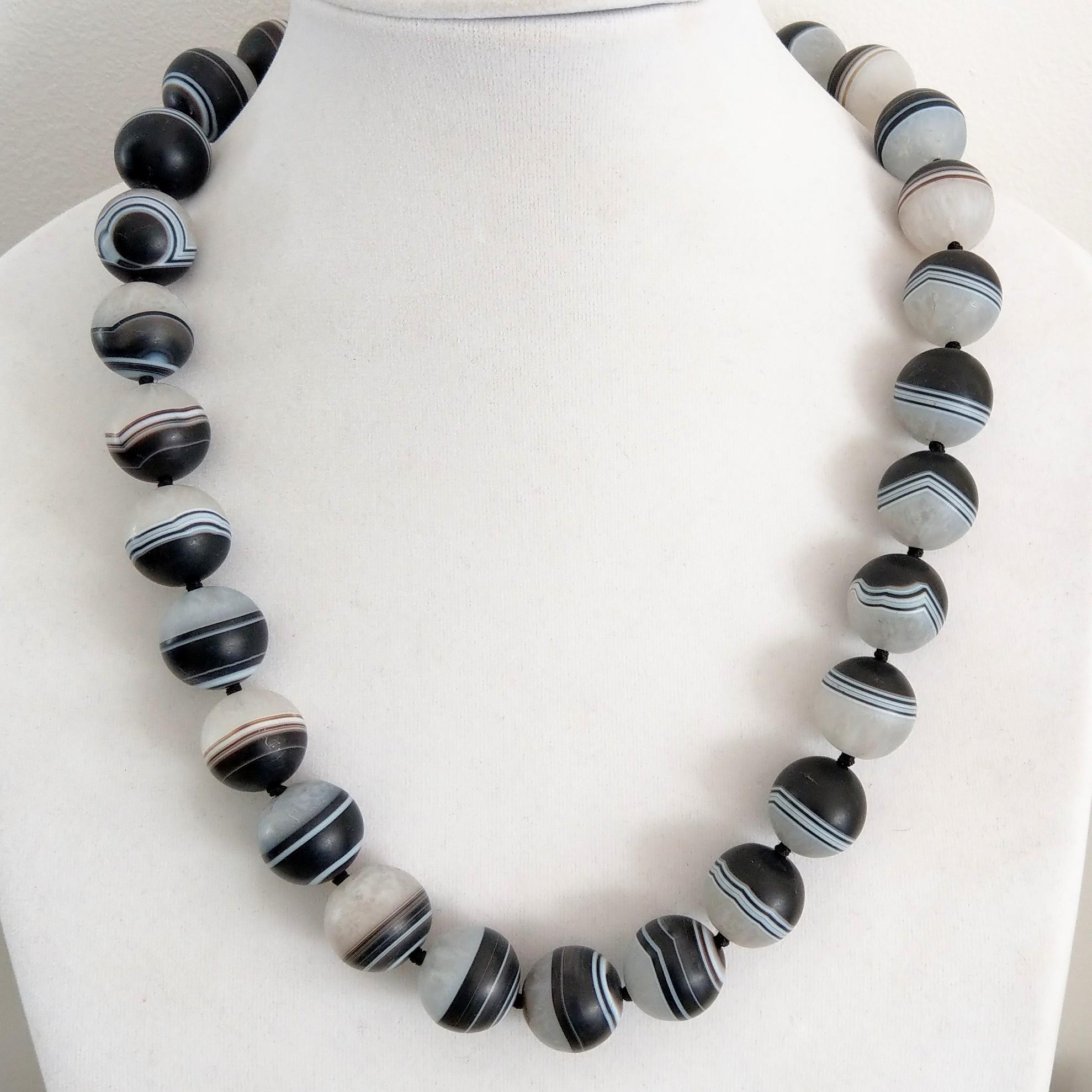 Stunning 18mm matt natural banded agate hand knotted on black thread with a large 55mm Sterling silver hook clasp


Finished necklace measures 57cm

