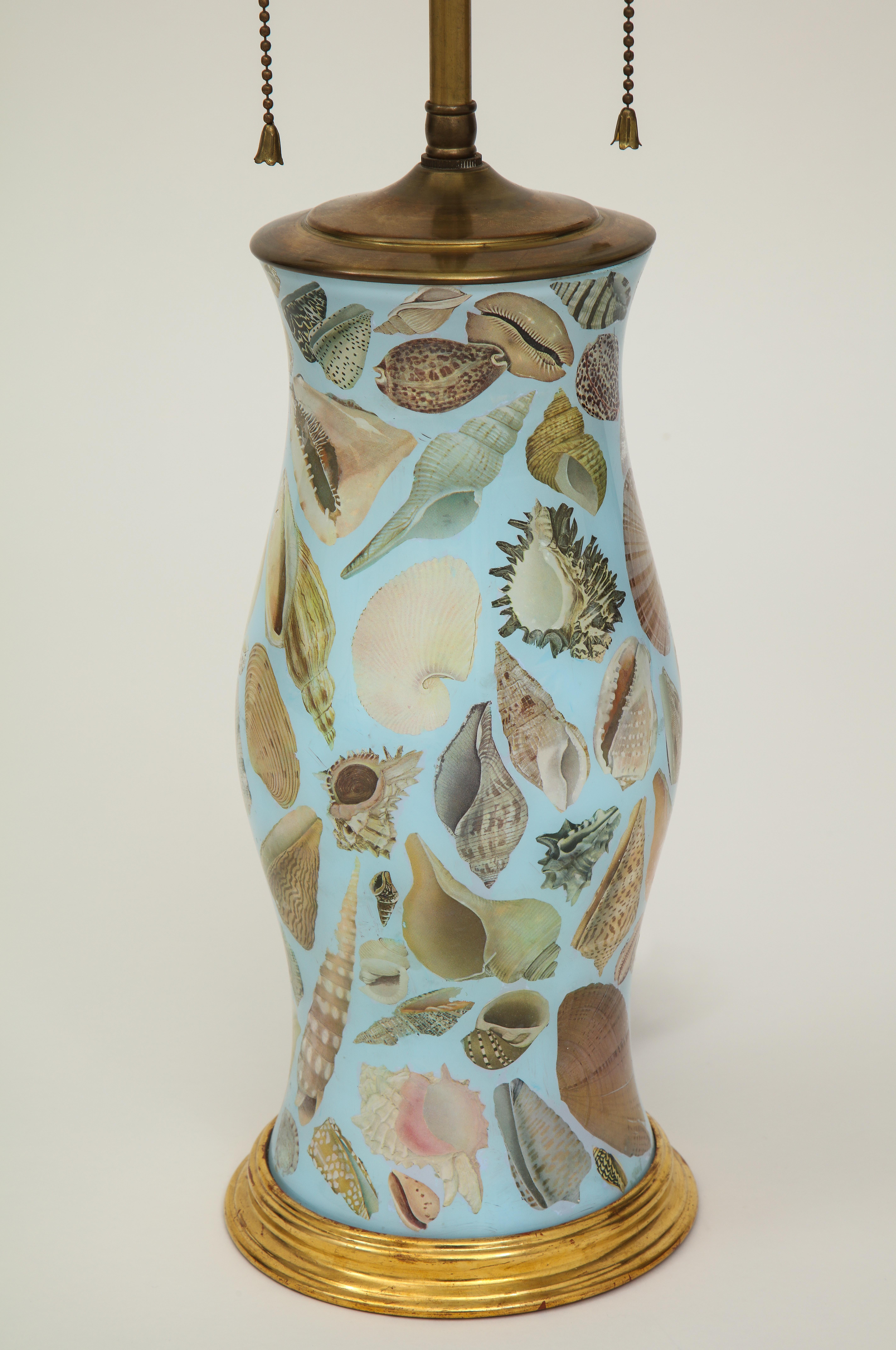 Featuring a charming variety of different seashells; on gilt base; mounted with two-light sockets and adjustable height. Height to top of vase is 13