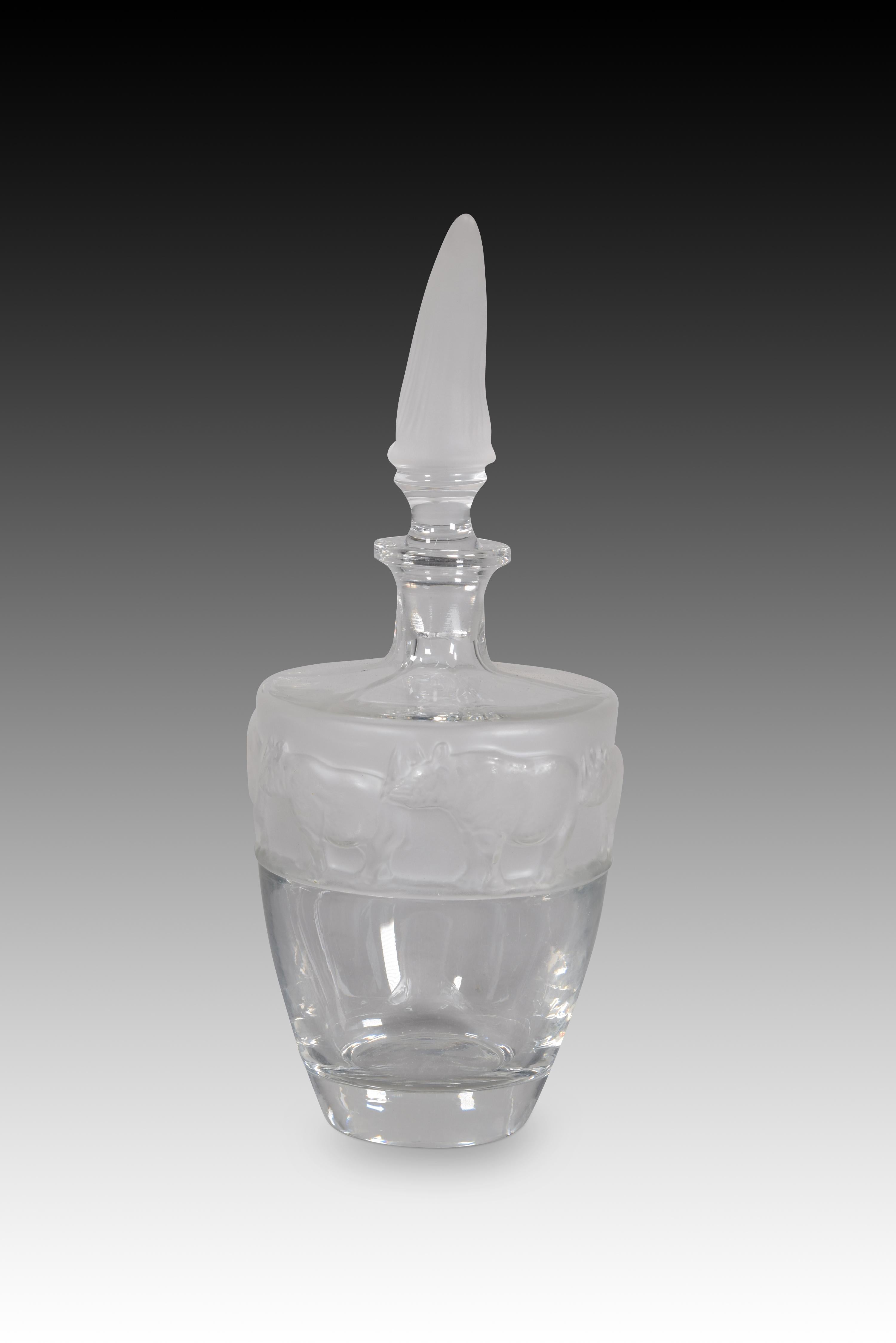 Decanter or bottle, Rhinoceros. Glass. Nachtmann, Germany, 20th century. 
Glass decanter or bottle with a stopper topped with a rhinoceros horn shape and a decoration of black rhinos on the top of the piece. It belongs to the Safari series.