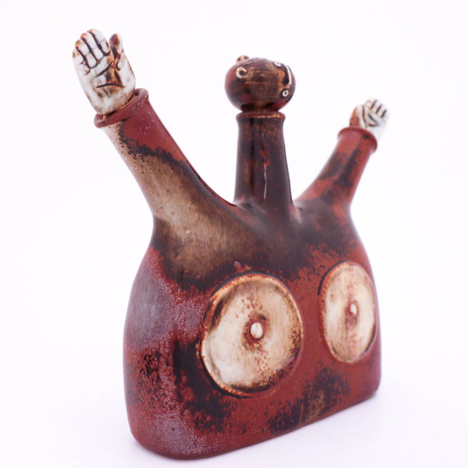 An unusual decanter / sculpture designed by Stig Lindberg at Gustavsbergs studio. It is made in black and brown stoneware and signed below with Stigs signature. The hands and the head is removable from the body.