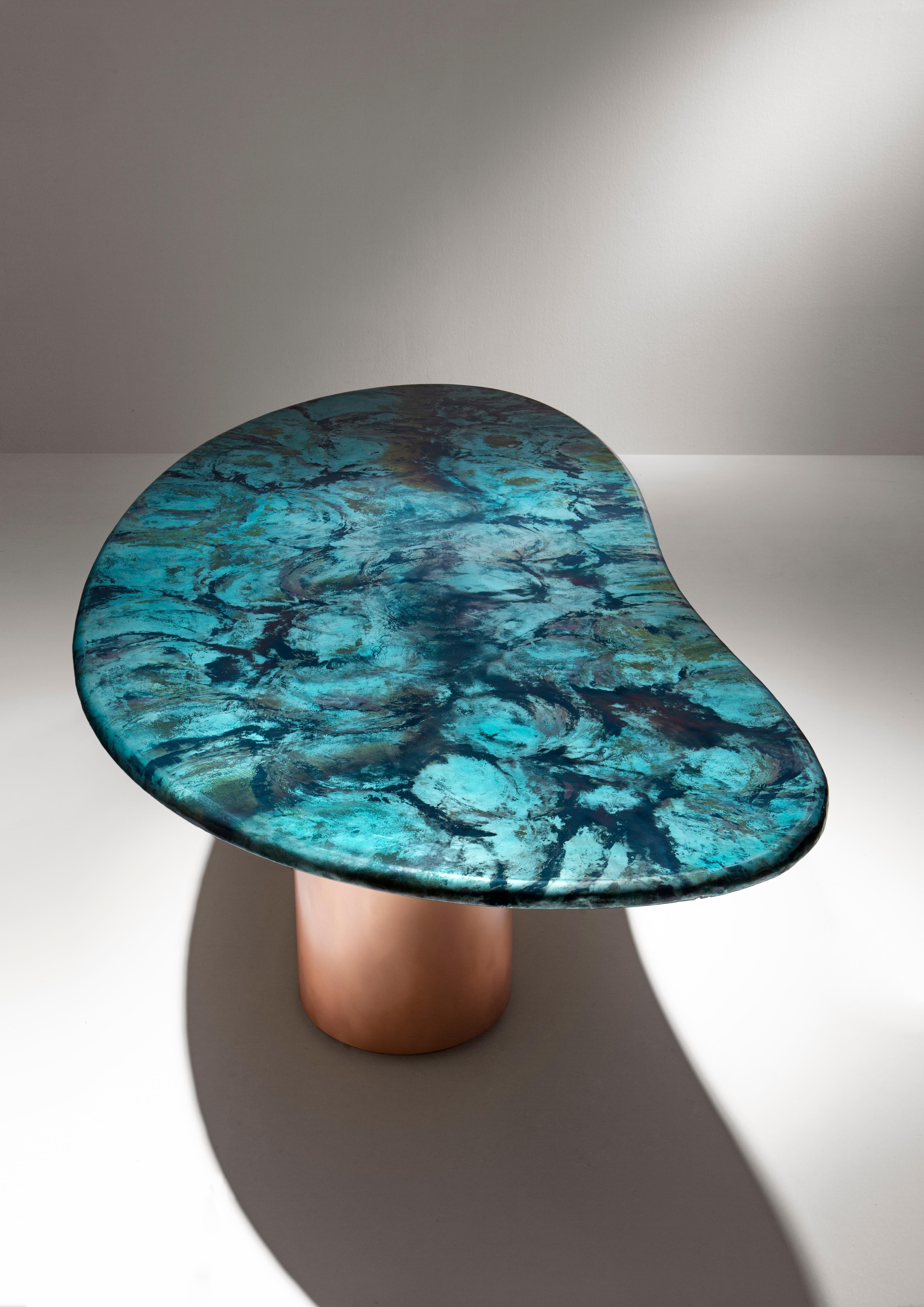 Large table characterized by an organic shape, inspired by the landscapes of the Venetian lagoon sea: the infinite variations given by the waves and the currents come to life in the evocative declinations of the DeNuance lagoon finish, with its many