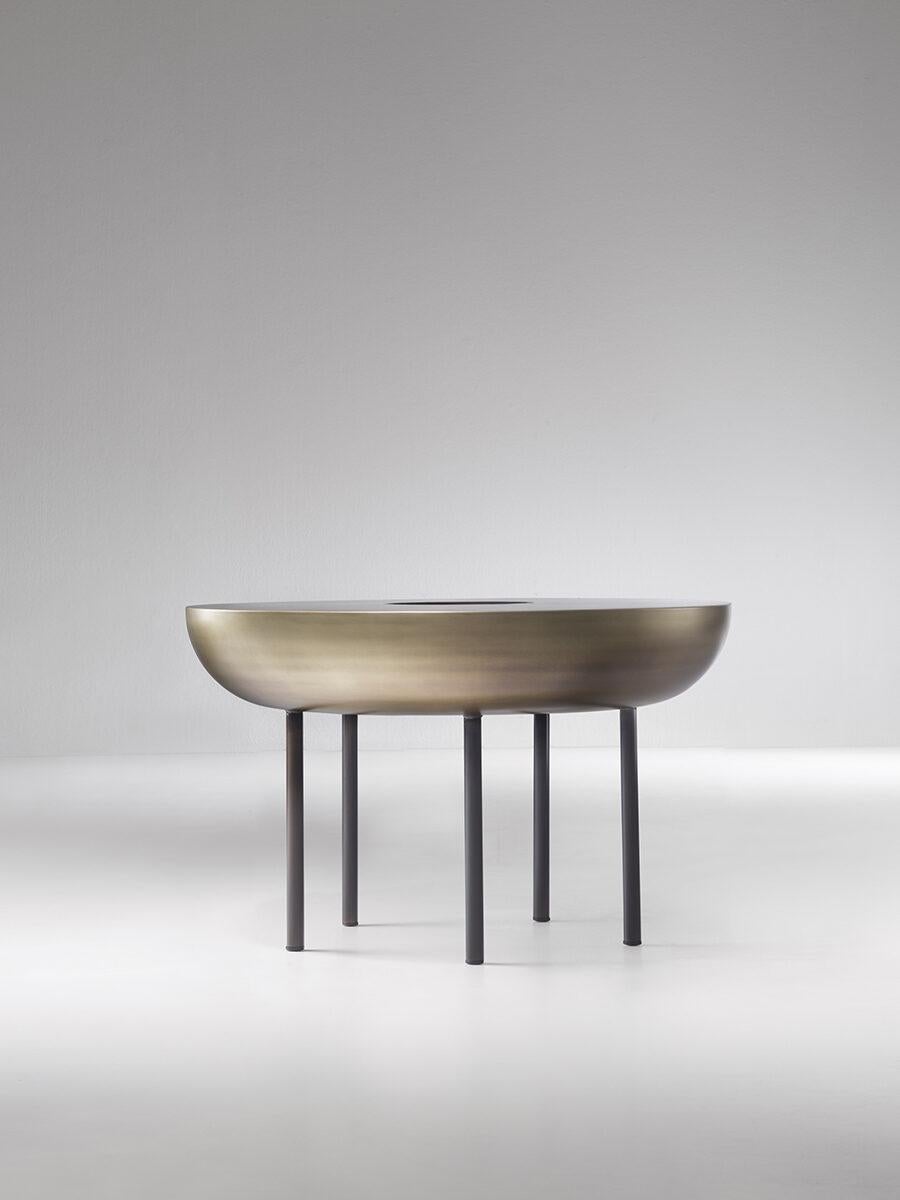 Botero, une grande table d'appoint en équilibre sur cinq pieds élancés, incarne une expertise technique raffinée dans ses détails et ironique dans son esthétique. La technique artisanale utilisée pour créer sa surface arrondie a été récupérée et