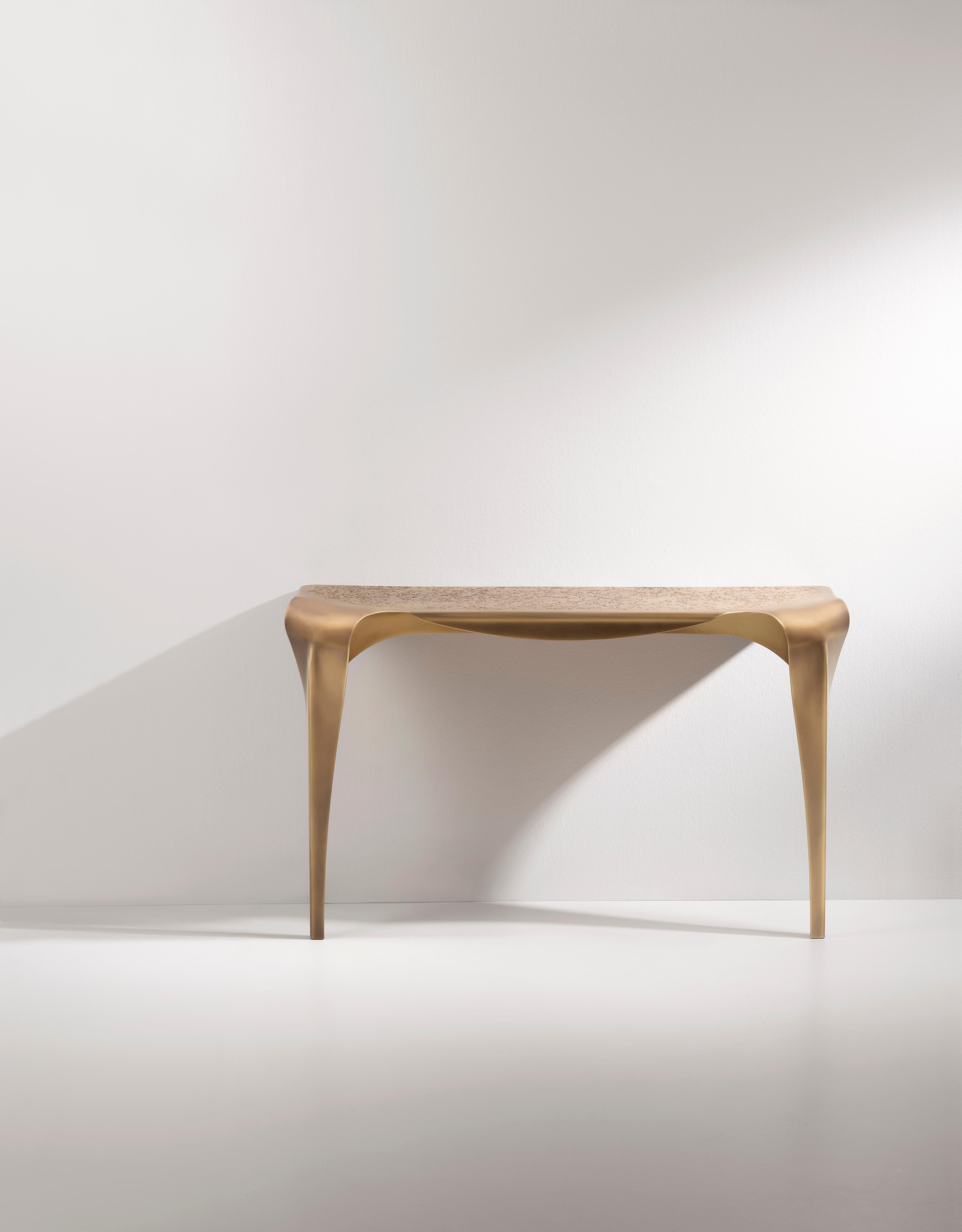 Inspiriert von dem gleichnamigen Tisch lehnt sich die Convivium-Konsole mit einer kurvenreichen und anmutigen Haltung an die Wand. Dieses vollständig aus Messing gefertigte Stück zeichnet sich durch die DeErosion-Behandlung der Platte und die