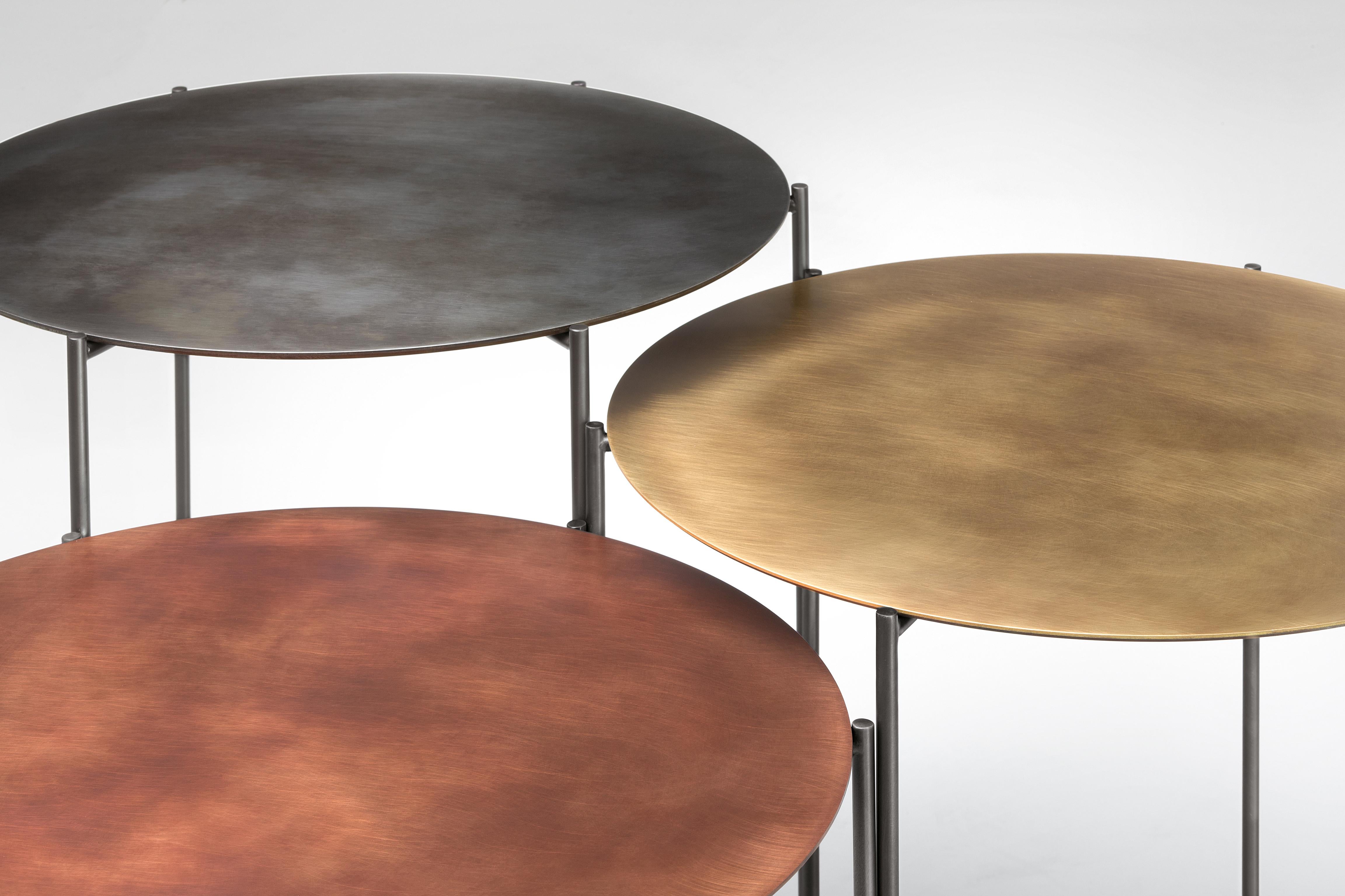 The Band coffee table set creates ‘micro architecture’ whose most distinctive trait is lightness. Long, slender legs support thin circular table tops, where metal nuances vibrate. In iron, brass and copper, these multifaceted objects gracefully and